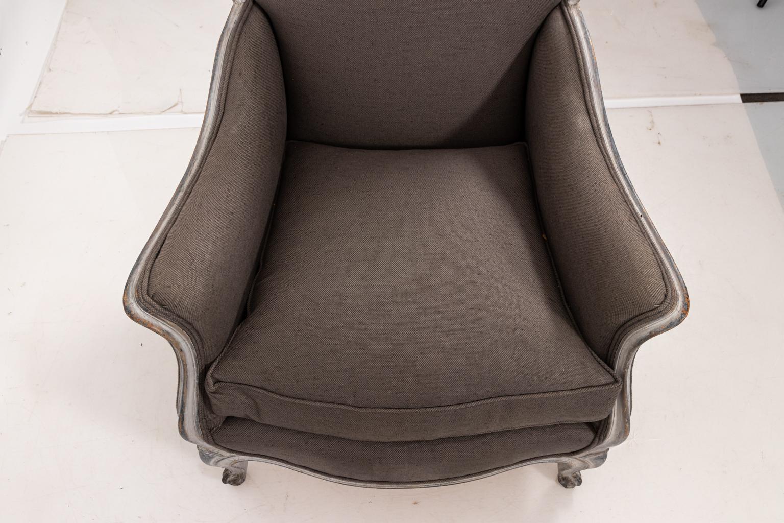 Louis XV style painted Bergère armchair that features gray Belgian linen and Rococo details including cabriole front legs, circa 1960s. The piece also includes a white painted carved frame with gray hued patinated finish. Please note of wear