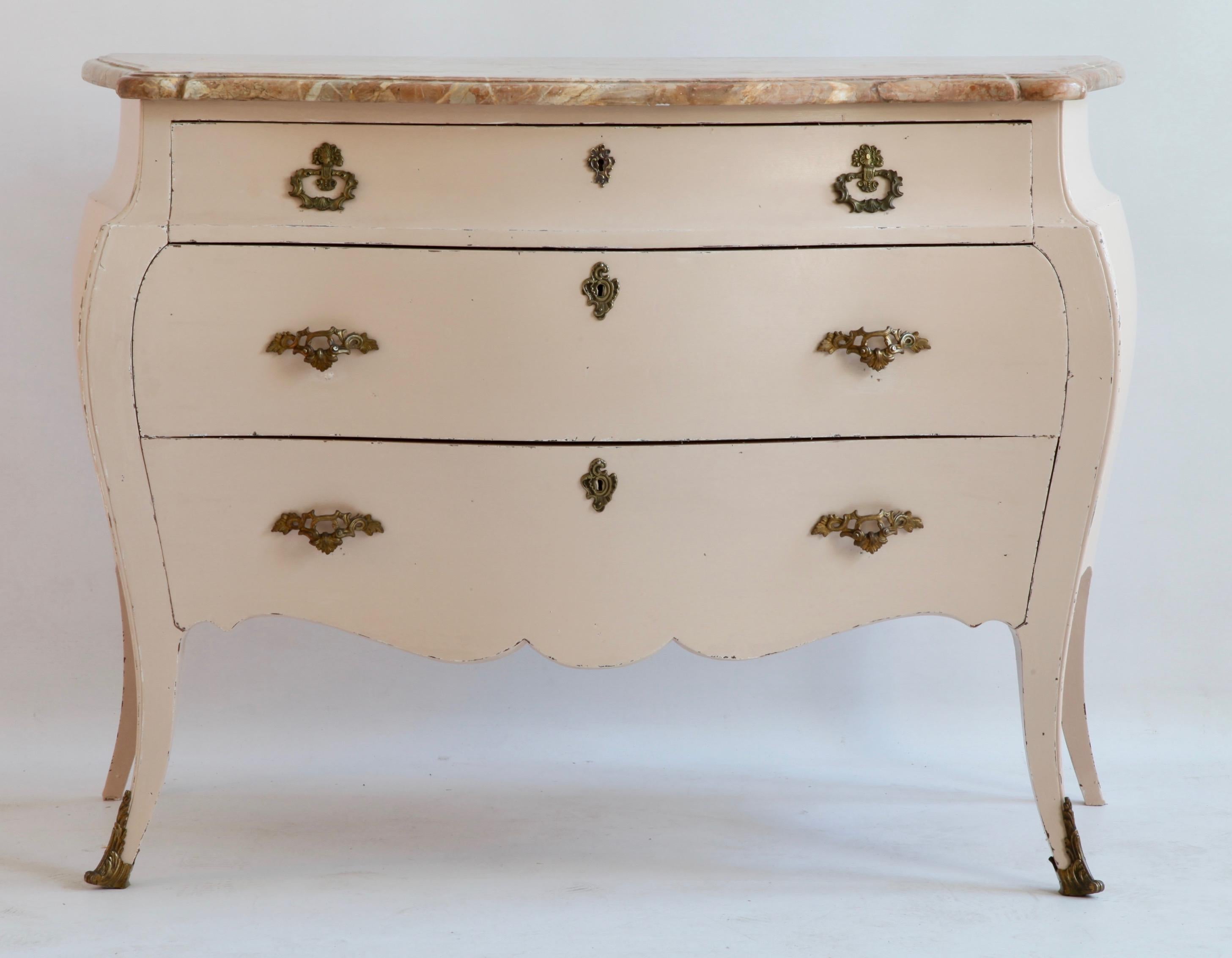 Late 19th century painted Bombe commode in the Louis XV style.
With a marble top. Painted in a warm pink, with bronzes handles.