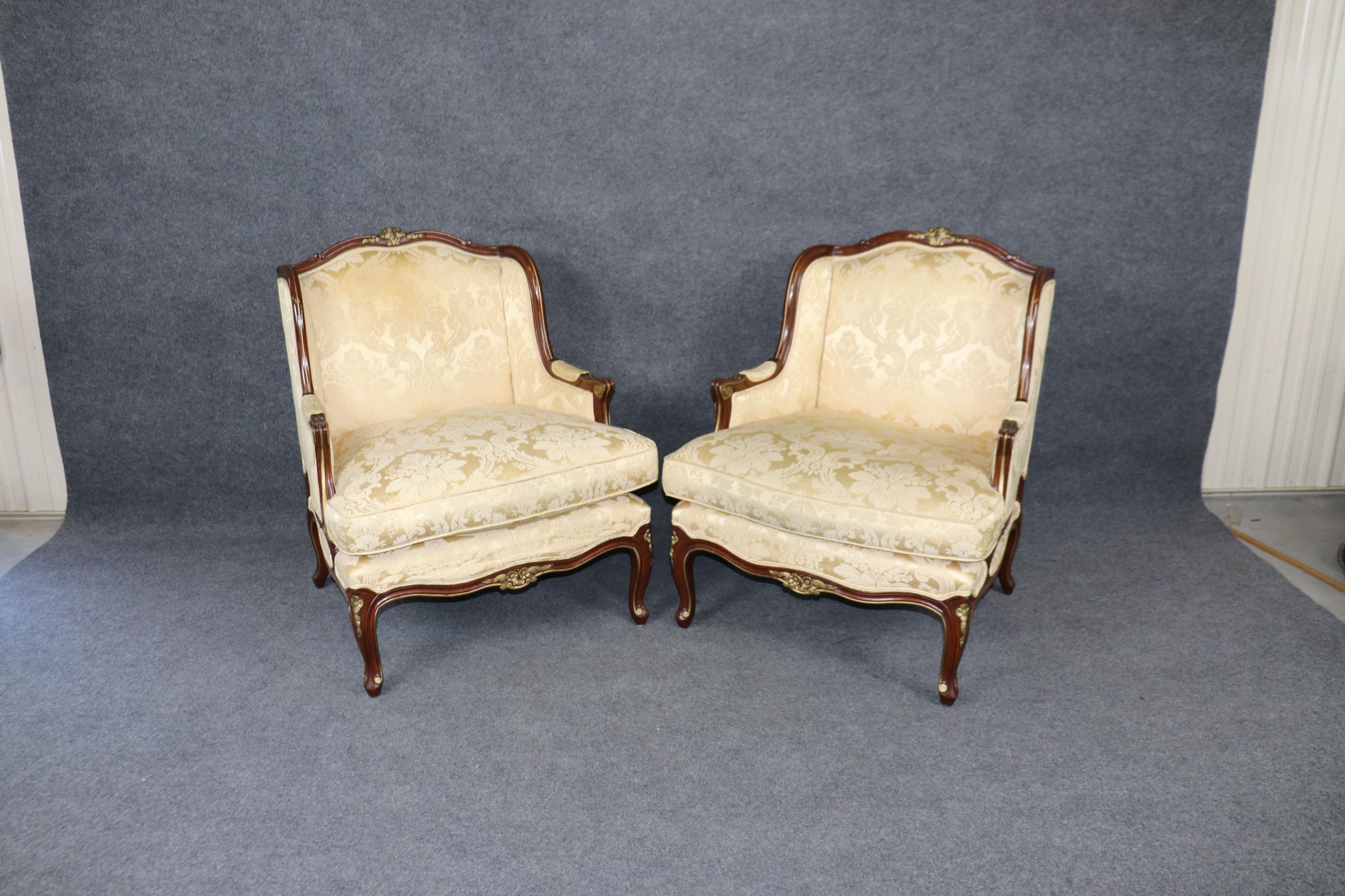 This is a gorgeous pair of gorgeous chairs in what we believe is silk damask. The chairs are done in a high polish and feature gorgeous carved gilded flowers. The frames are in good condition with minor signs of age and use. The upholstery is in