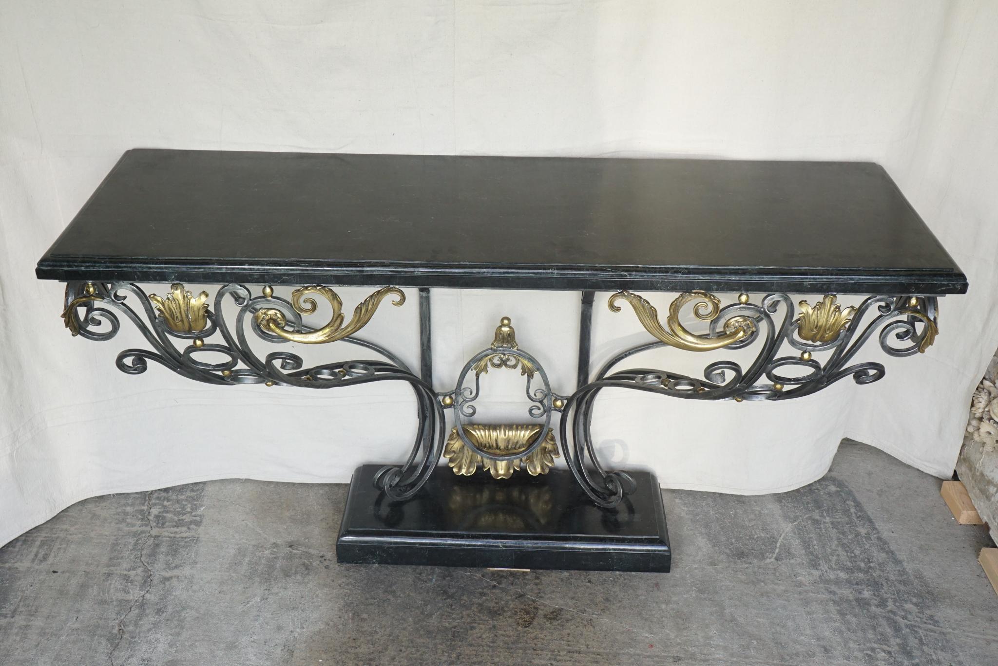 This large and impressive wrought iron Louis XV style console, crafted in the 1980s, is accented with large polished cast bronze mounts consisting of acanthus leaves, laurel leaves and ball spacers between the steel elements. The table wall mounts