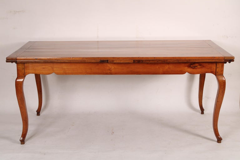 Louis XV provincial style fruit wood refectory dining table, circa 1930's. Great fruit wood color. The pull out leaves are darker than the top. Made from antique and later elements. Length when fully extended 141.5