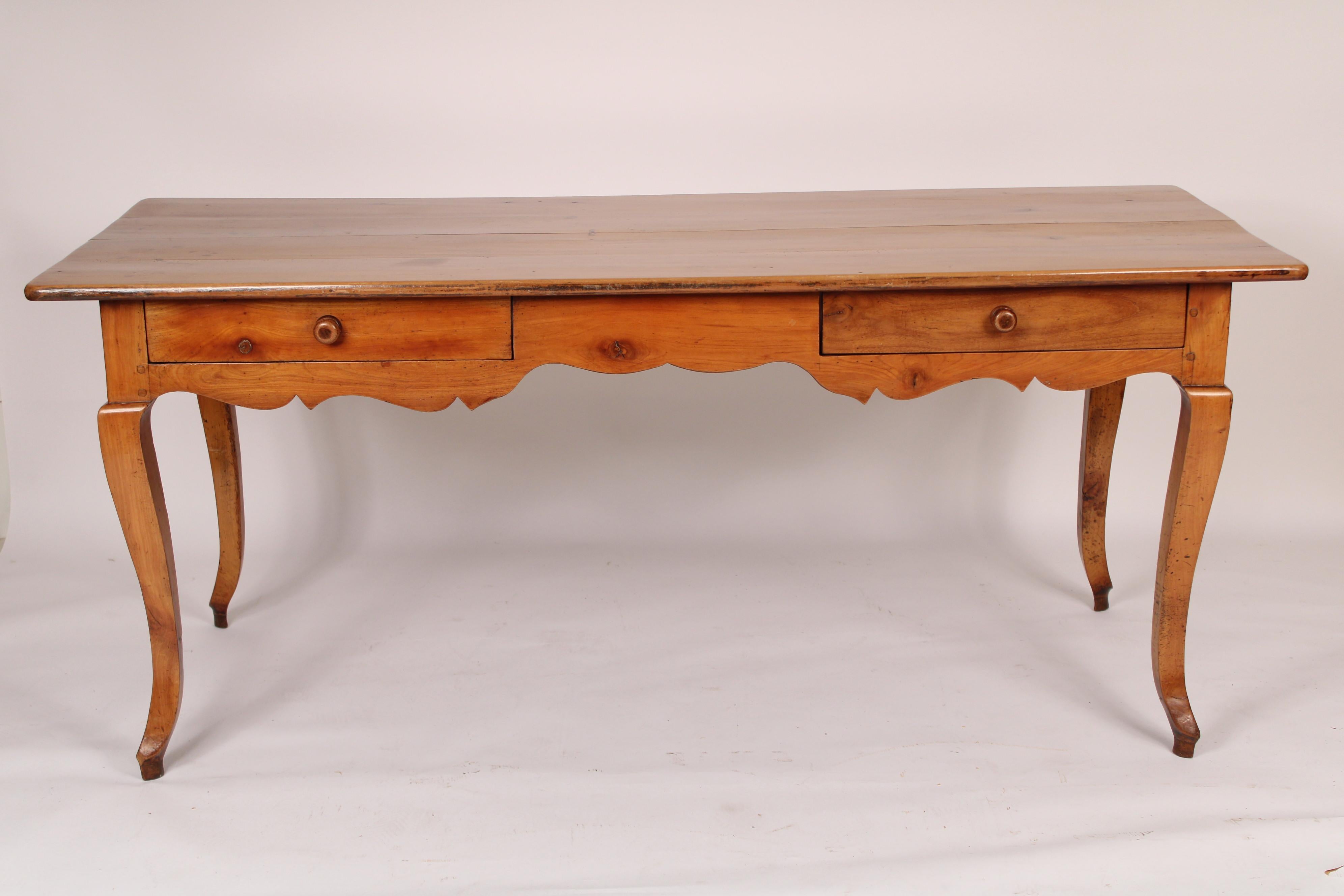 Louis XV provincial style fruit wood writing table, made from 19th century and later elements. With a 4 board rectangular fruit wood overhanging top, two frieze / desk drawers, a scalloped apron, resting on cabriole legs. Converted into a desk from