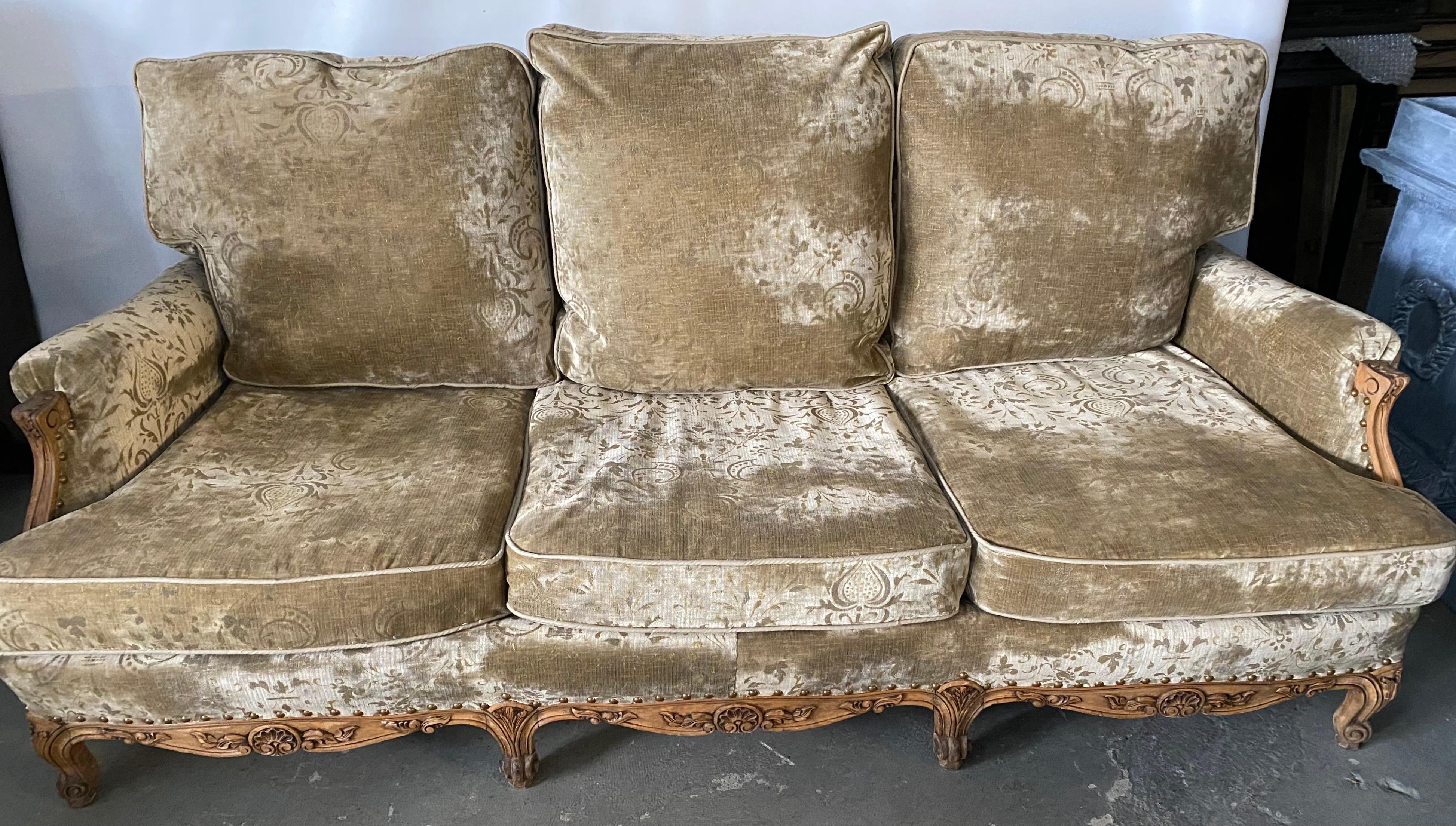 Grand French over stuffed sofa or canapé made in the Louis XV Provincial style featuring large triple loose back and seat cushions. Sofa made with generous proportions providing extra comfort. Supported by eight hand carved cabriole legs, the frame