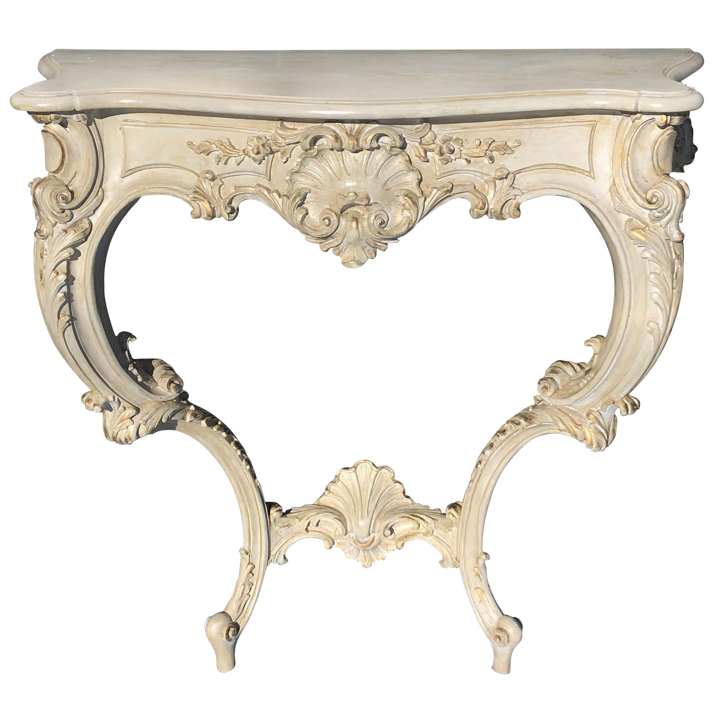 Table console de style Louis XV en relief sculptée et peinte en ivoire antique et dorée à la feuille