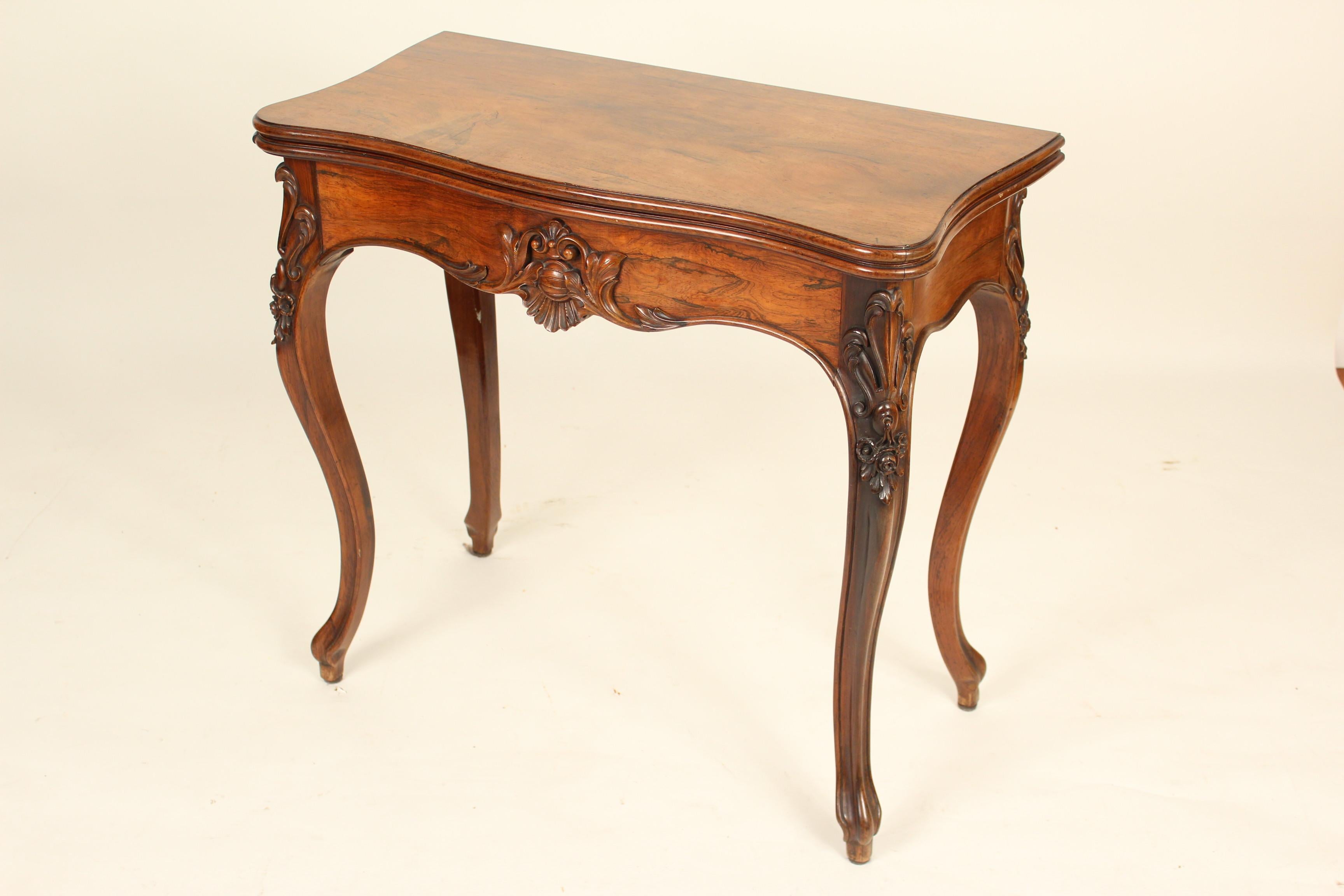 Louis XV style rosewood games table with concertina action, circa 1900. The rosewood on this games table has excellent color and grain. The interior on this games table is felt with a narrow tooled leather border. The height when the games table is