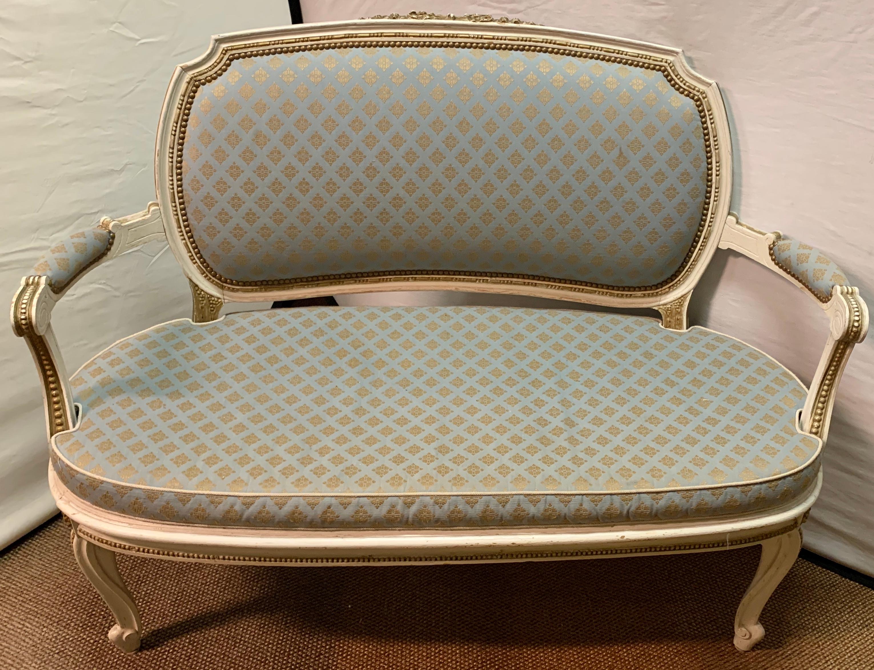 Louis XV style salon set. Pair of armchairs, settee and side chair. This finely carved paint and parcel gilt decorated set comprised of four pieces all in stabile sturdy condition. The circa 1920s or 1930s frames are distressed with cane backrests.
