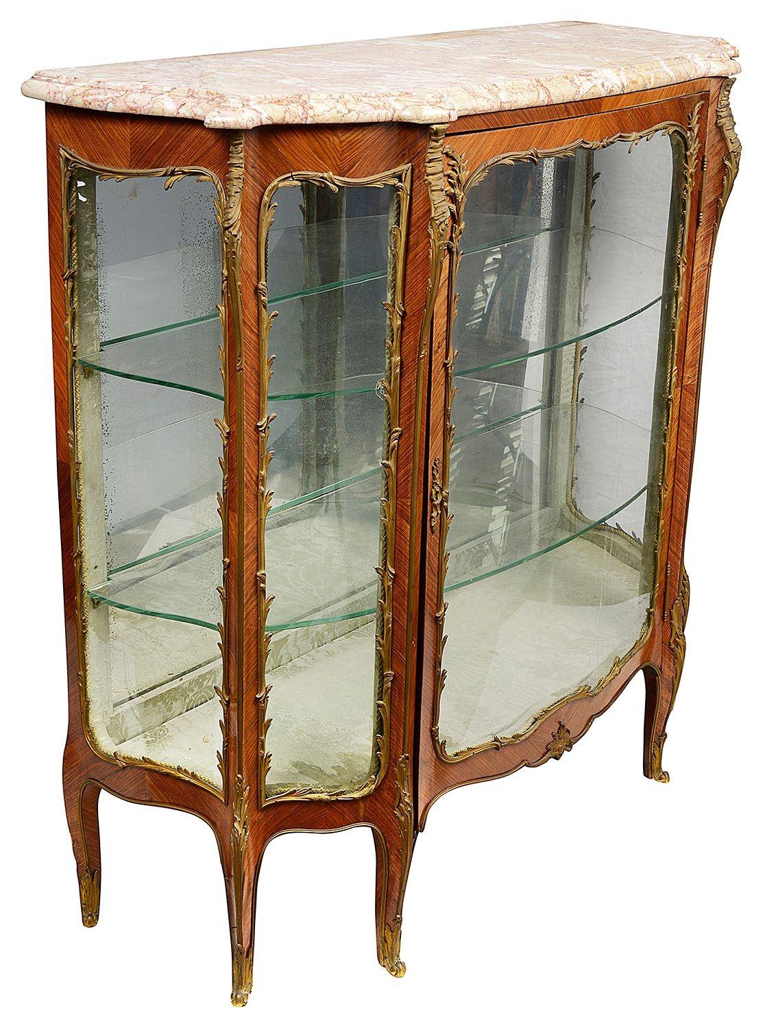 A very good quality late 19th Century French Kingwood veneered serpentine fronted, marble topped vitrine. Having scrolling foliate gilded ormolu mounts, adjustable glass shelves within and raised on elegant cabriole legs, circa 1890.

Batch 85 VT
