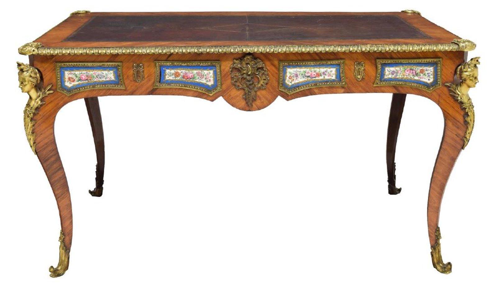 Spectacular mid-19th century French Louis XV style Sèvres and bronze mounted Kingwood veneered bureau plat with leather top.
The rectangular moulded top with inset tooled maroon leather writing surface within a finely decorated gilt bronze border,