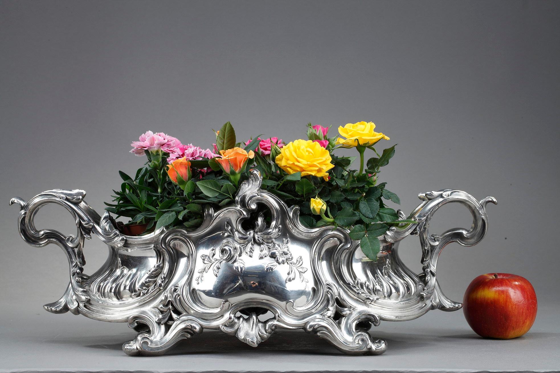 This beautiful Napoleon III period silvered bronze centerpiece, which can also be used as a jardinière, is completely in the Louis XV style, with its decorations of foliage. 

The Louis XV style is characterized by its lightness, its elegance and
