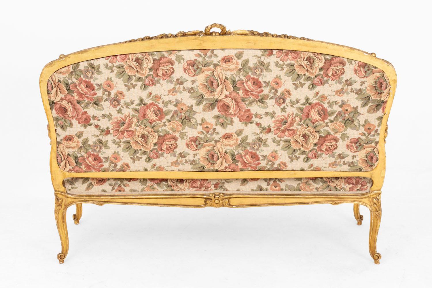 Louis XV style sofa in giltwood standing on four cabriole legs finished by scrolls and decorated with acanthus leaves. Scalloped apron with a decor of swags with flowers.
Arm supports slightly behind the leg line and adorned with acanthus leaves.