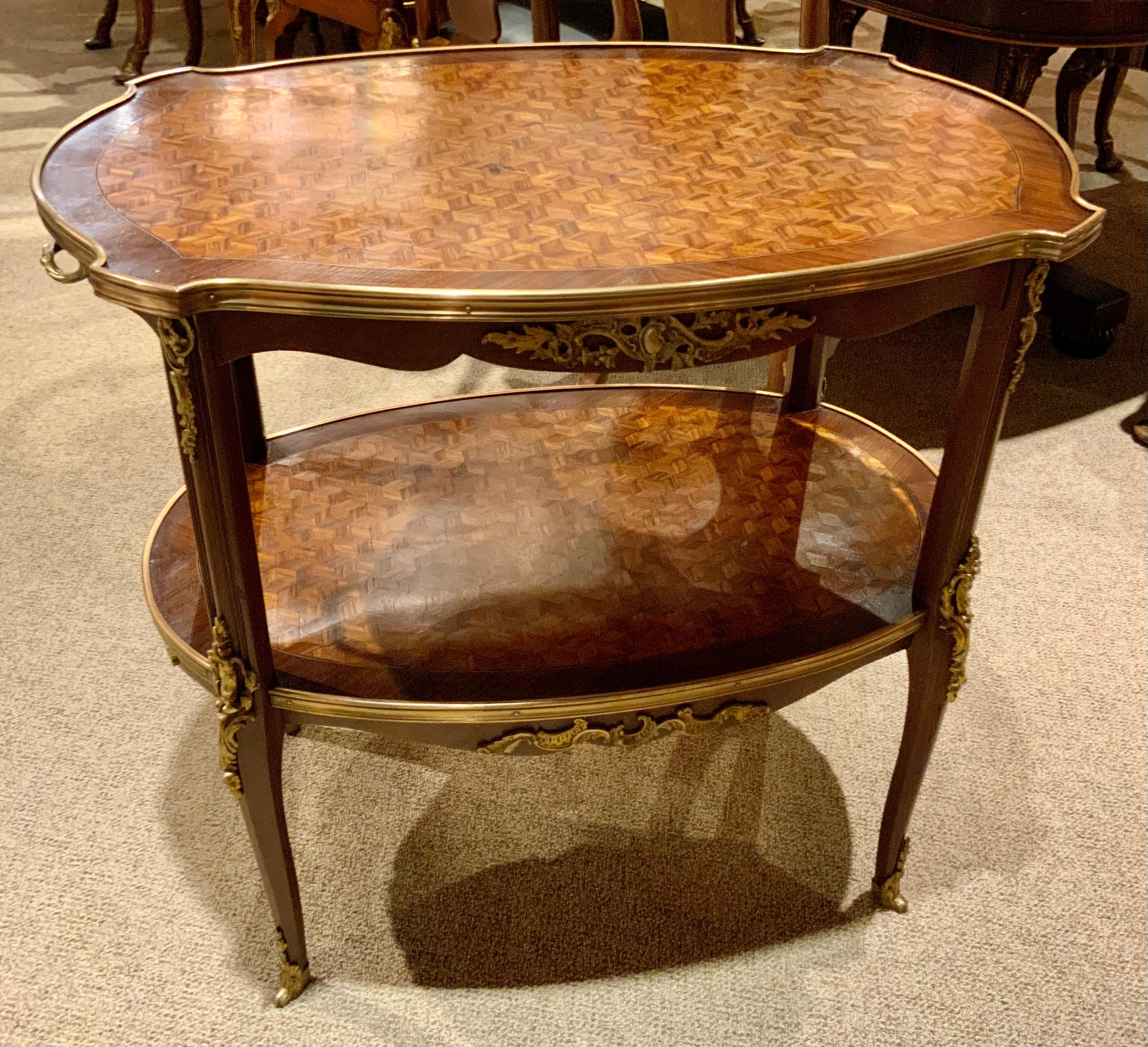 The parquetry inlay is fine quality workmanship and the
Bronze mounts have beautiful castings and the gilding
Is exceptional. This table has two tiers and works well
As a tea table or side table for serving. It is stable and
Very sturdy without