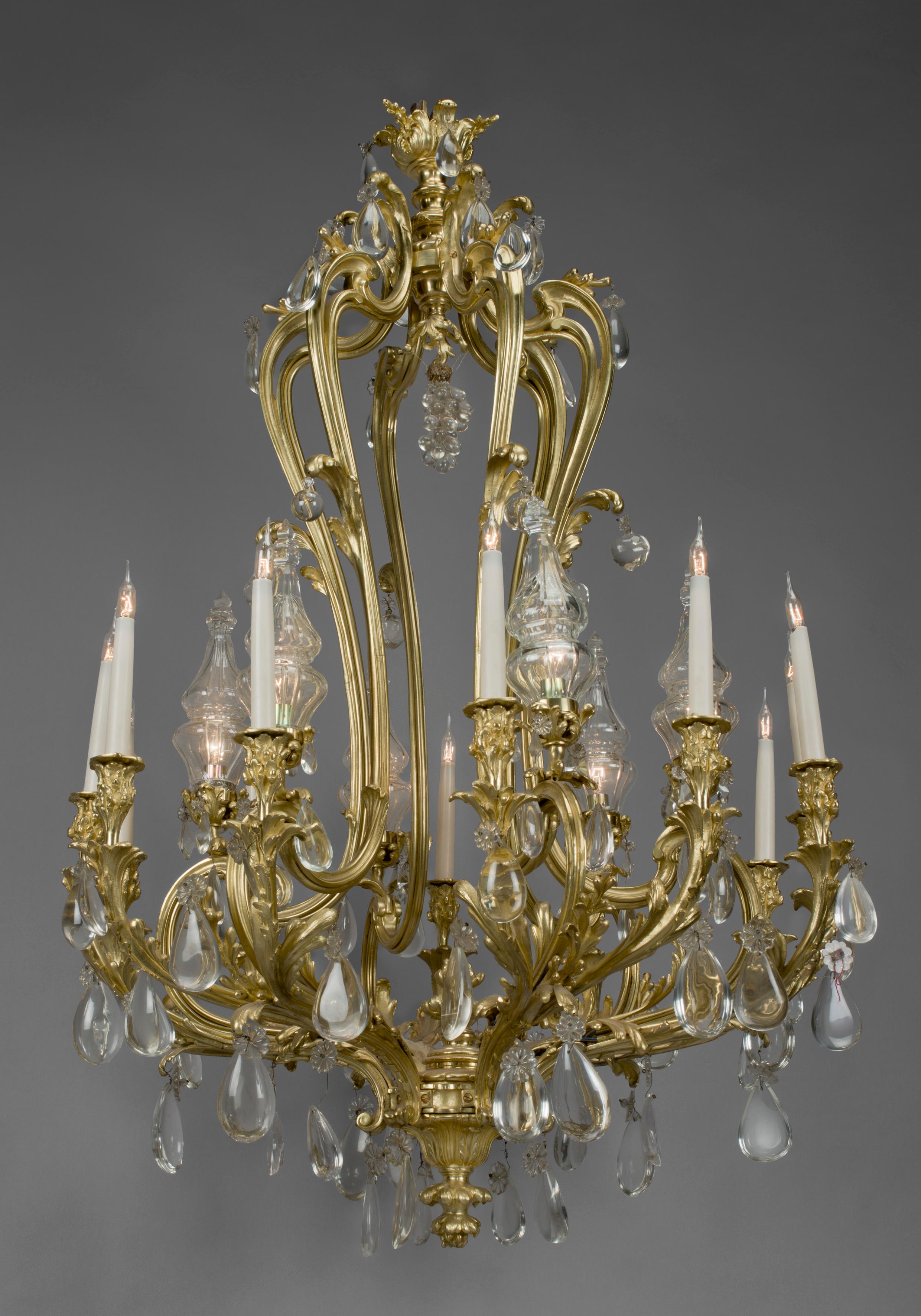 Importante lampadario a dodici luci in cristallo di rocca e bronzo dorato in stile Luigi XV.

Francese, circa 1850. 

Importante lampadario a dodici luci in cristallo di rocca e bronzo dorato in stile Luigi XV, sormontato da una corona floreale