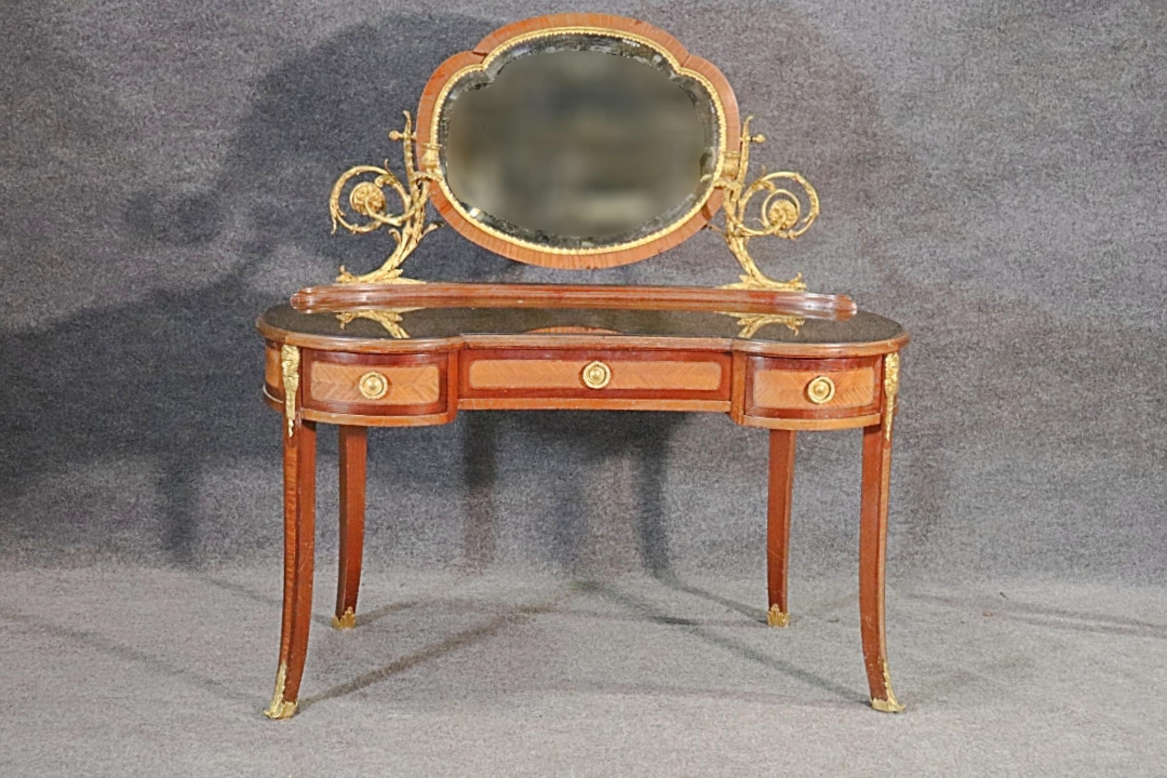Louis  Meuble-lavabo de style XV avec miroir en bronze  & Cadre. Dans la forêt de Manière. Le meuble-lavabo est en noyer avec un miroir en bronze et des chandeliers.  Le meuble-lavabo comporte 3 tiroirs et un plan de travail en verre. Le miroir est