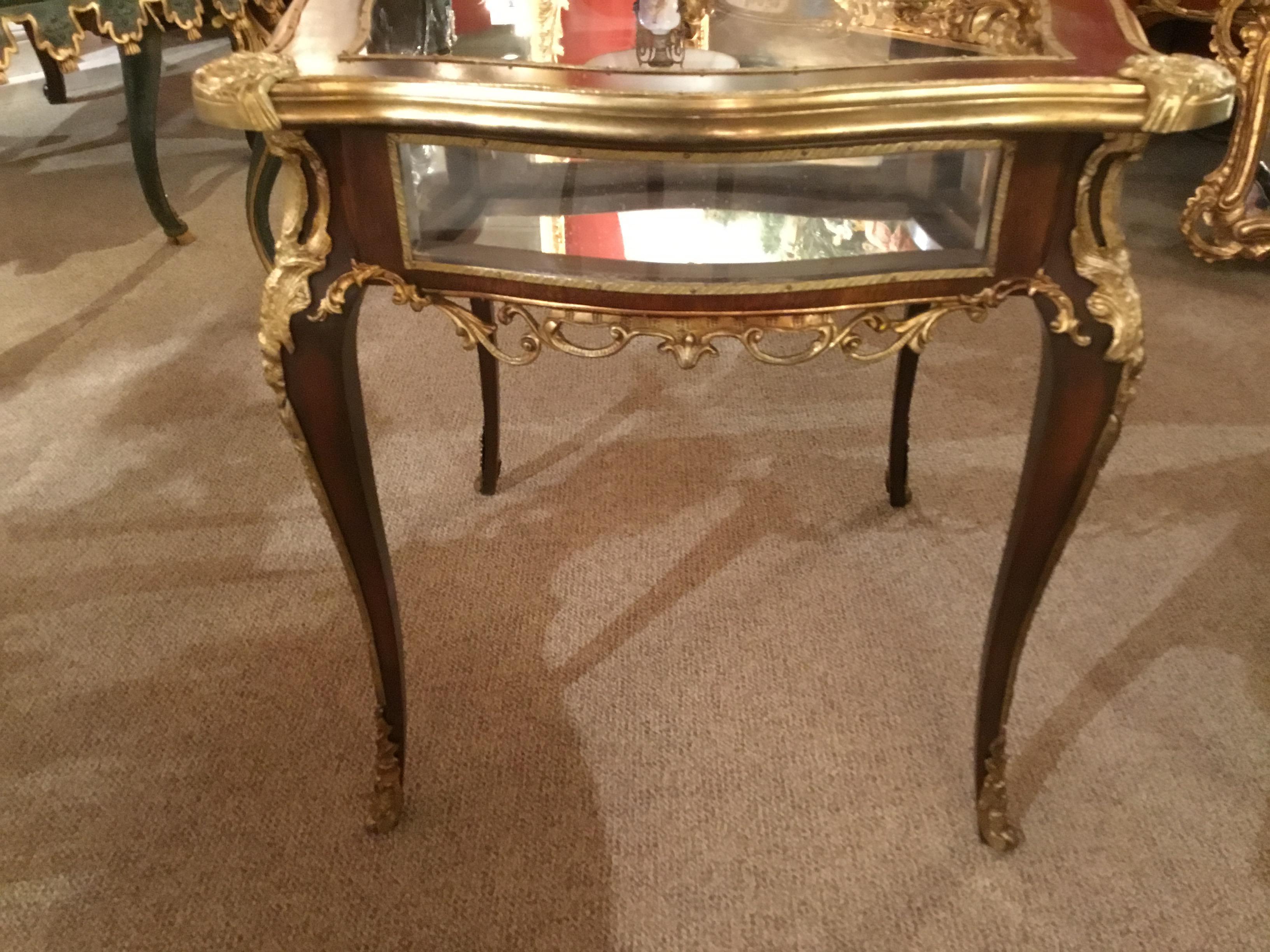 French Louis XV style display table with a glass top for viewing into
The interior with a mirrored bottom. It has a hinged top opening to
The interior for easy placement. Curved panels on the sides, and all
Rising on curved cabriole legs.