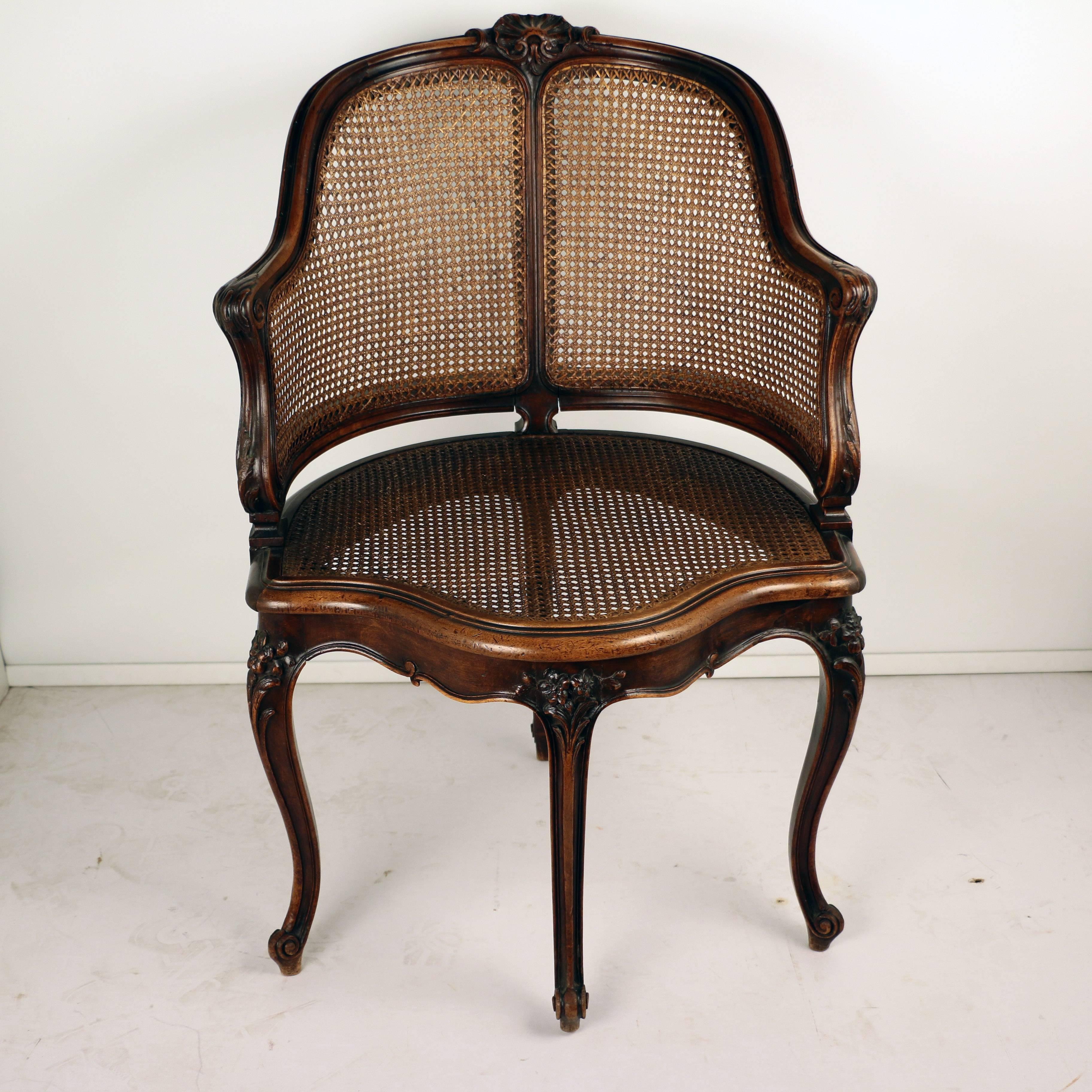 This shapely corner armchair has unusually positioned legs. The curving arms ,legs and caned sides and seat all contribute a sense of lightness , the carving is excellent. 