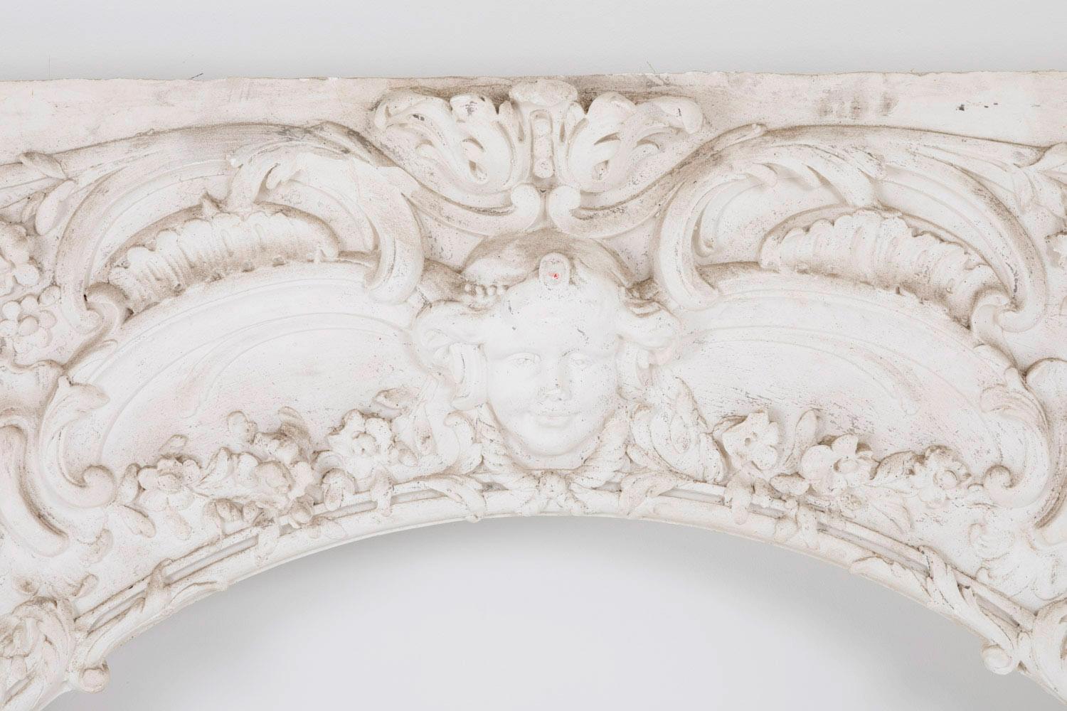 Louis XV style rectangular stucco wood panel with a oval shaped central hole surrounding by carved ornament such as flowers, foliage, scrolls, acanthus leaves ; in the upper central part is decorated with a putto mascaron.

Panel mounted on a