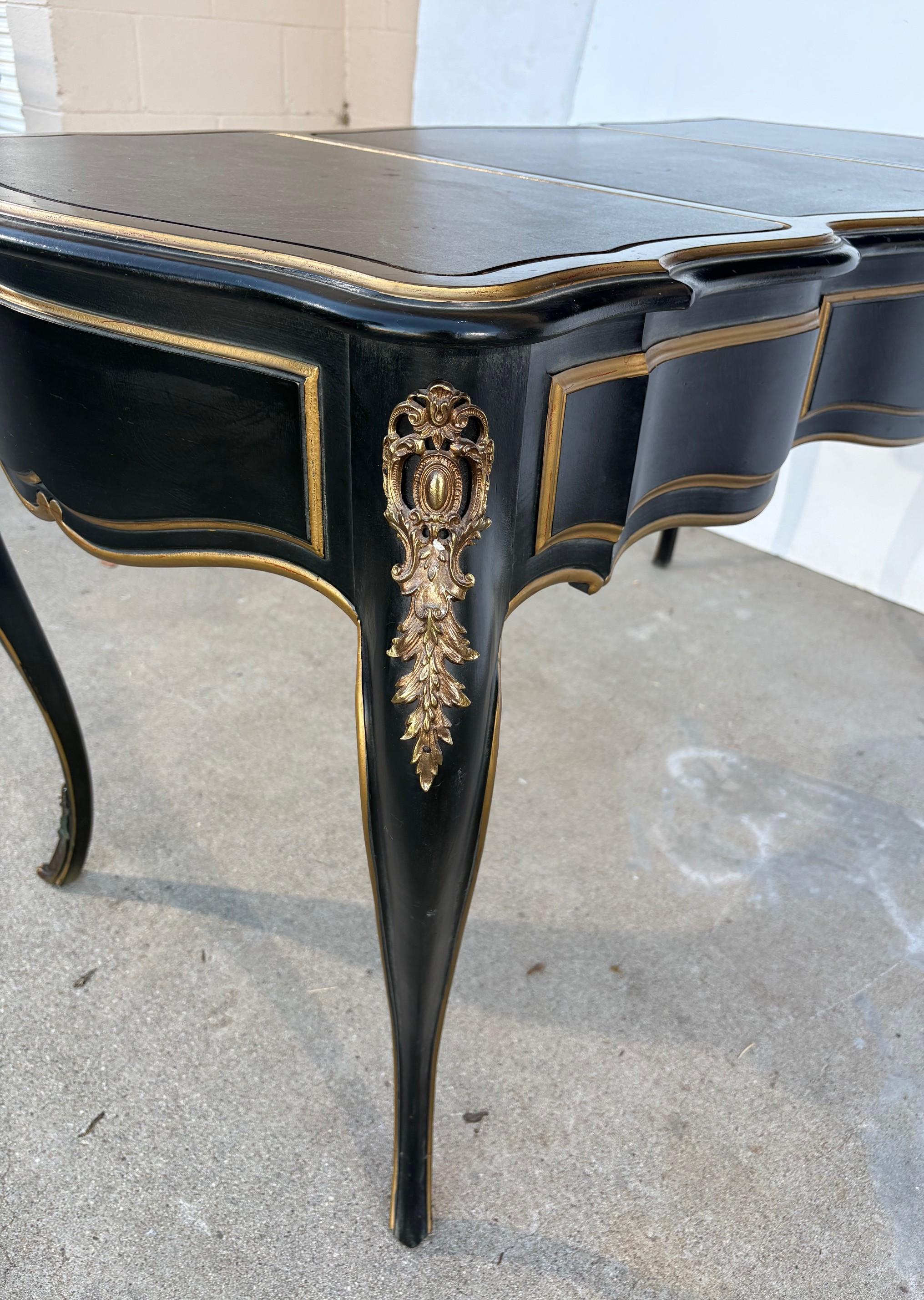 Ein Schreibpult im Stil von Louis XV. Die Oberseite ist aus Kunstleder gefertigt. Es hat drei Schubladen mit goldenen Akzenten.