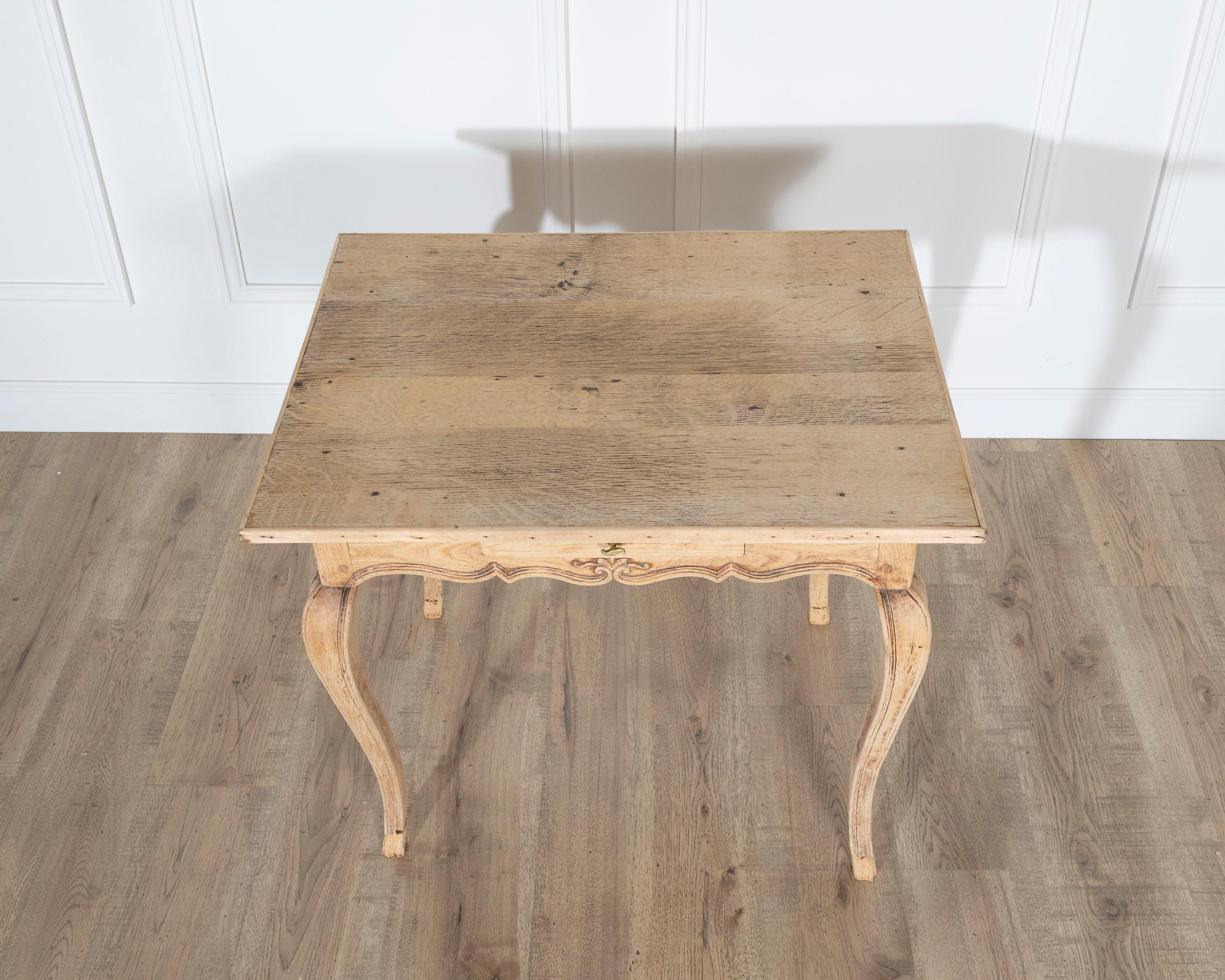Charmante table à écrire de style Louis XV du XIXe siècle, fabriquée en chêne naturel. Le plateau rectangulaire présente une surface magnifiquement adoucie, marquée par le caractère subtil que seuls l'âge et l'usage peuvent apporter. En dessous, le