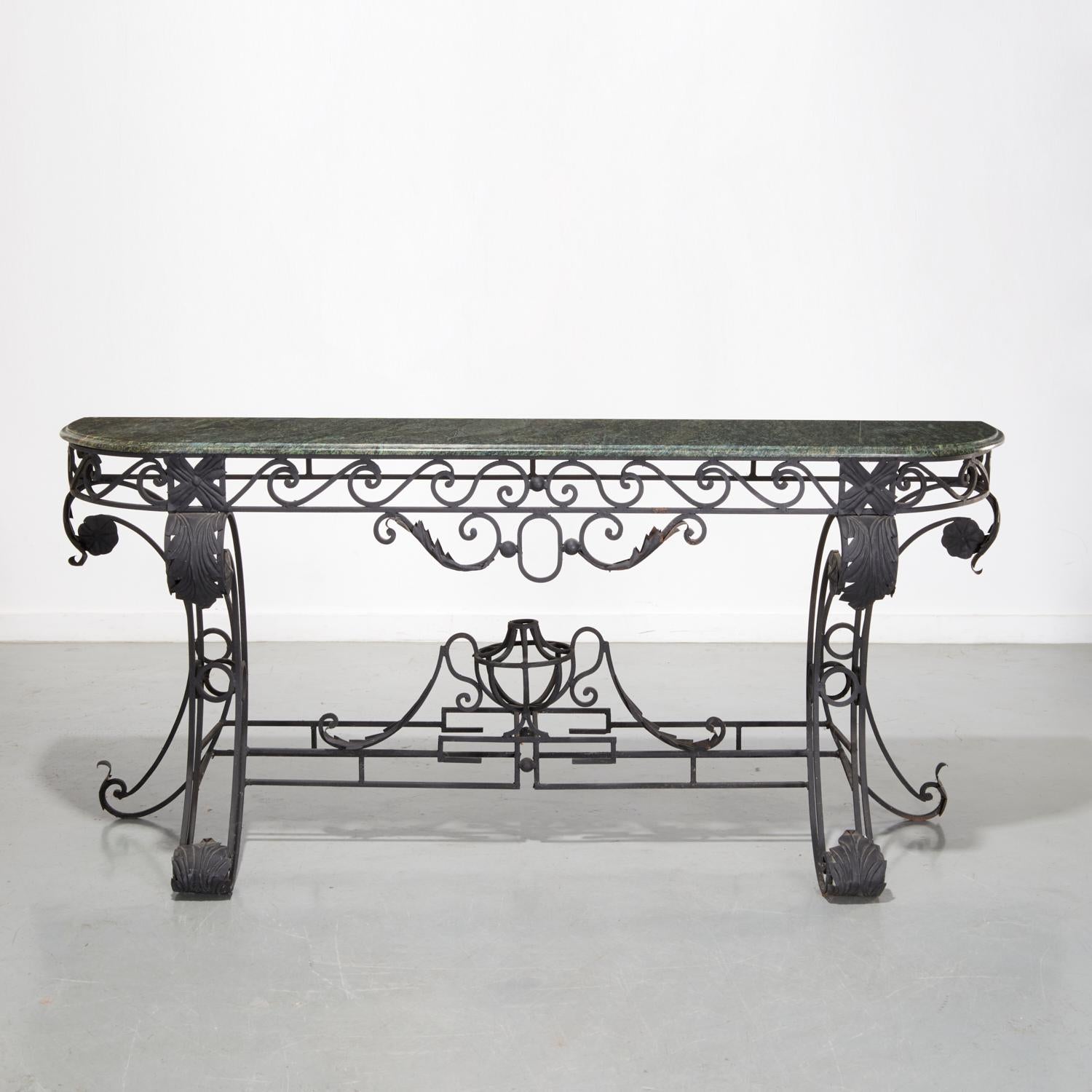 A grand and elegant wrought iron console table in the Louis XV style, dating to the early to mid-20th century. The hand-forged iron base is composed of intricately scrolled supports, stylized acanthus leaves, and symmetrical flourishes, all