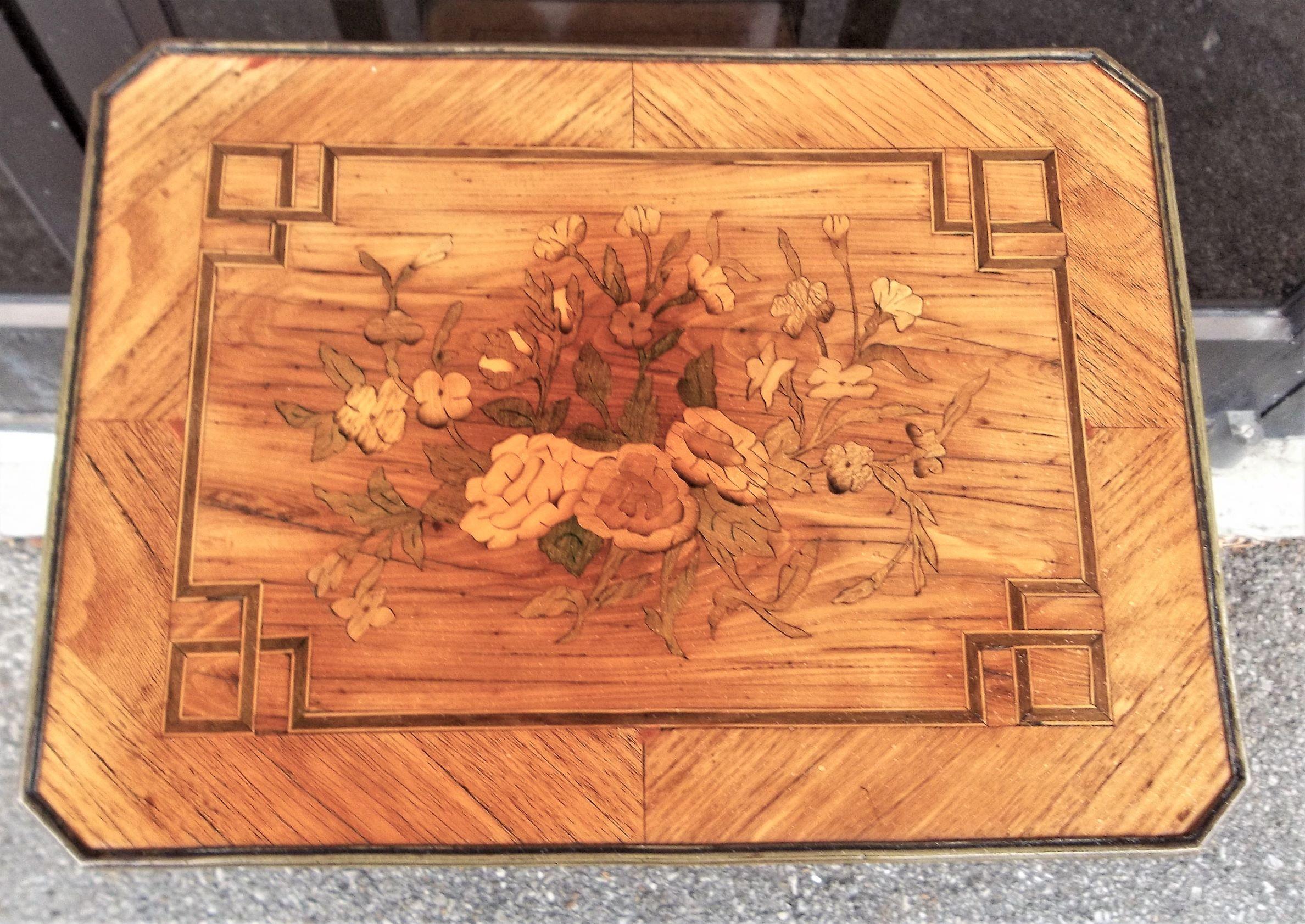 Tulipwood and fruitwoods with the top and stretcher inlaid in a floral marquetry pattern. All four sides with a geometric and stylized rosette inlay. Lovely honey color and patina with a side drawer and frontal slide.

Fading, minor wood losses,