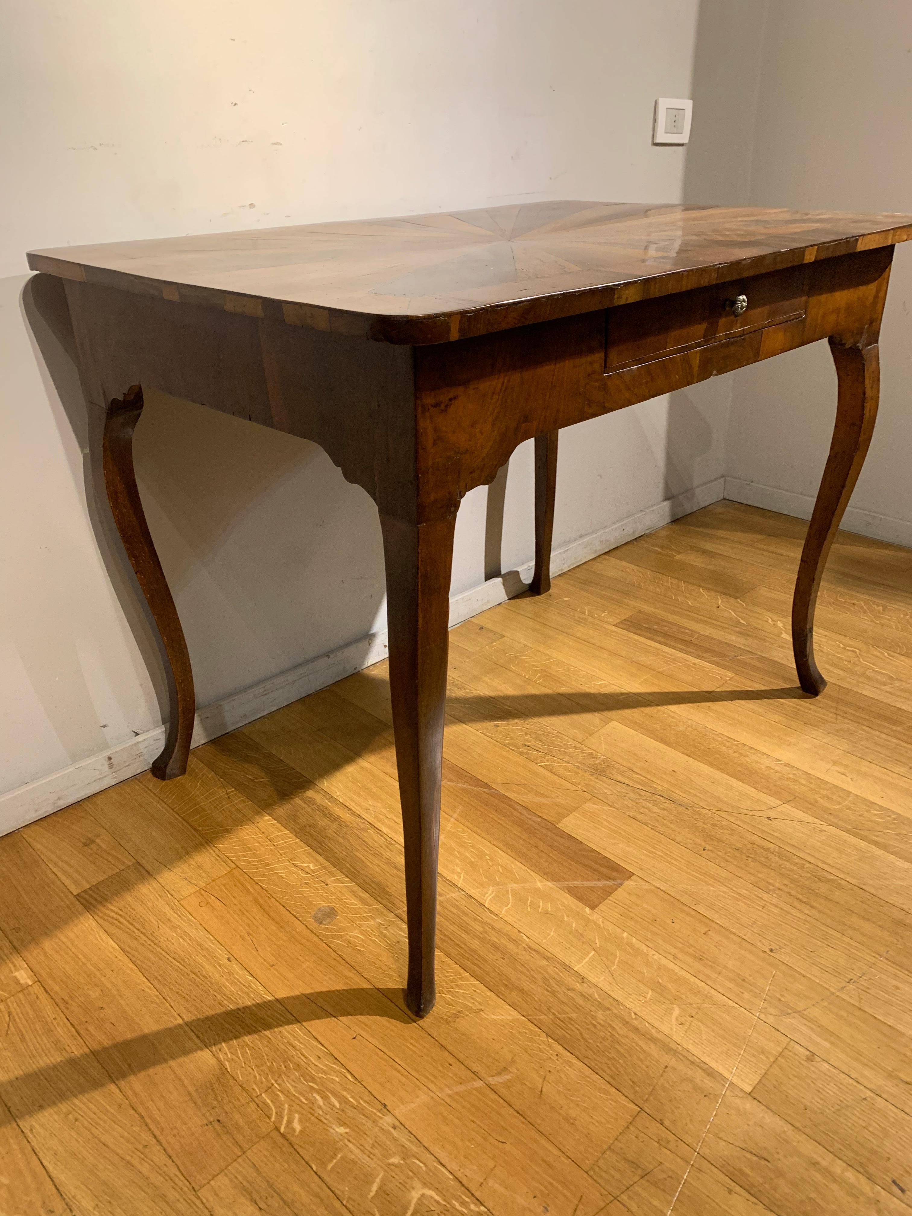Elegant writing table in walnut veenered poplar. Top centered by a star motif, a comfortable drawer in the band, curved legs typical of mid-18th century Tuscan manufacture.
