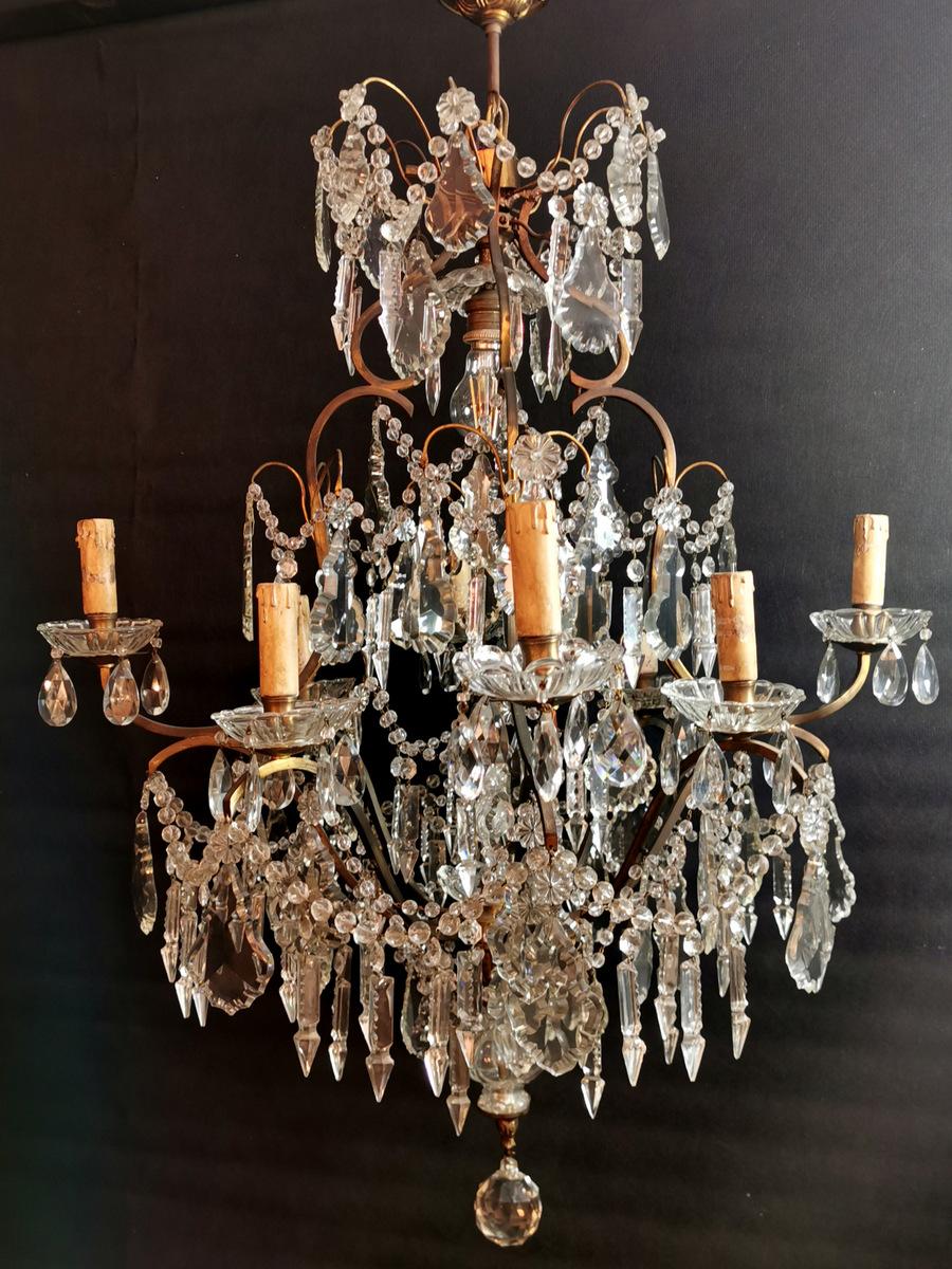 Rich and fascinating Italian chandelier; its robust structure is in bronze, it is very elegant and well proportioned; numerous and massive lead crystals, with different shapes, spherical, florets, jagged leaf, arrow, and teardrops were then expertly