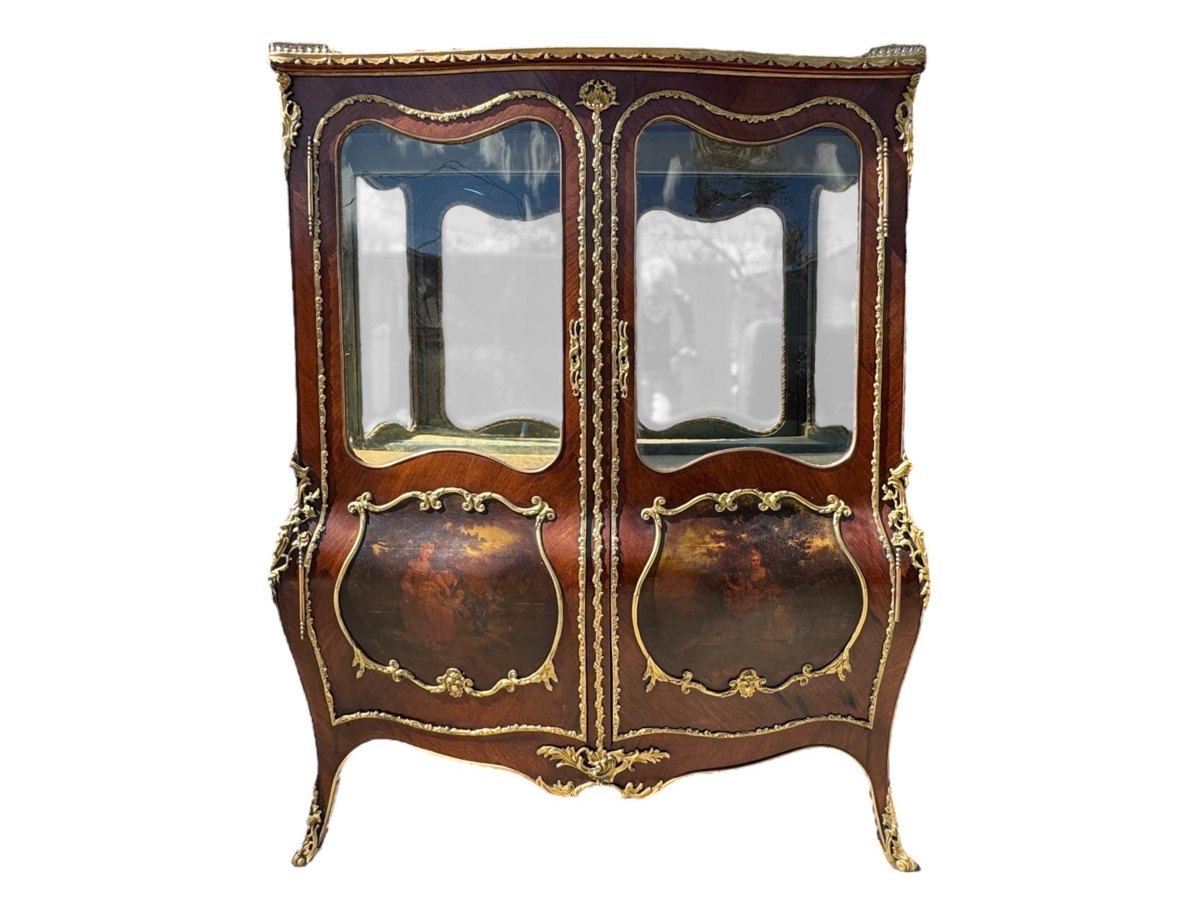 Una splendida coppia di grandi vetrine francesi in stile Louis XV, alla maniera di Vernis Martin, circa 1900. Decorate con impiallacciature di mogano alla fiamma, le vetrine sono riccamente decorate con bronzo dorato. La base bombata presenta