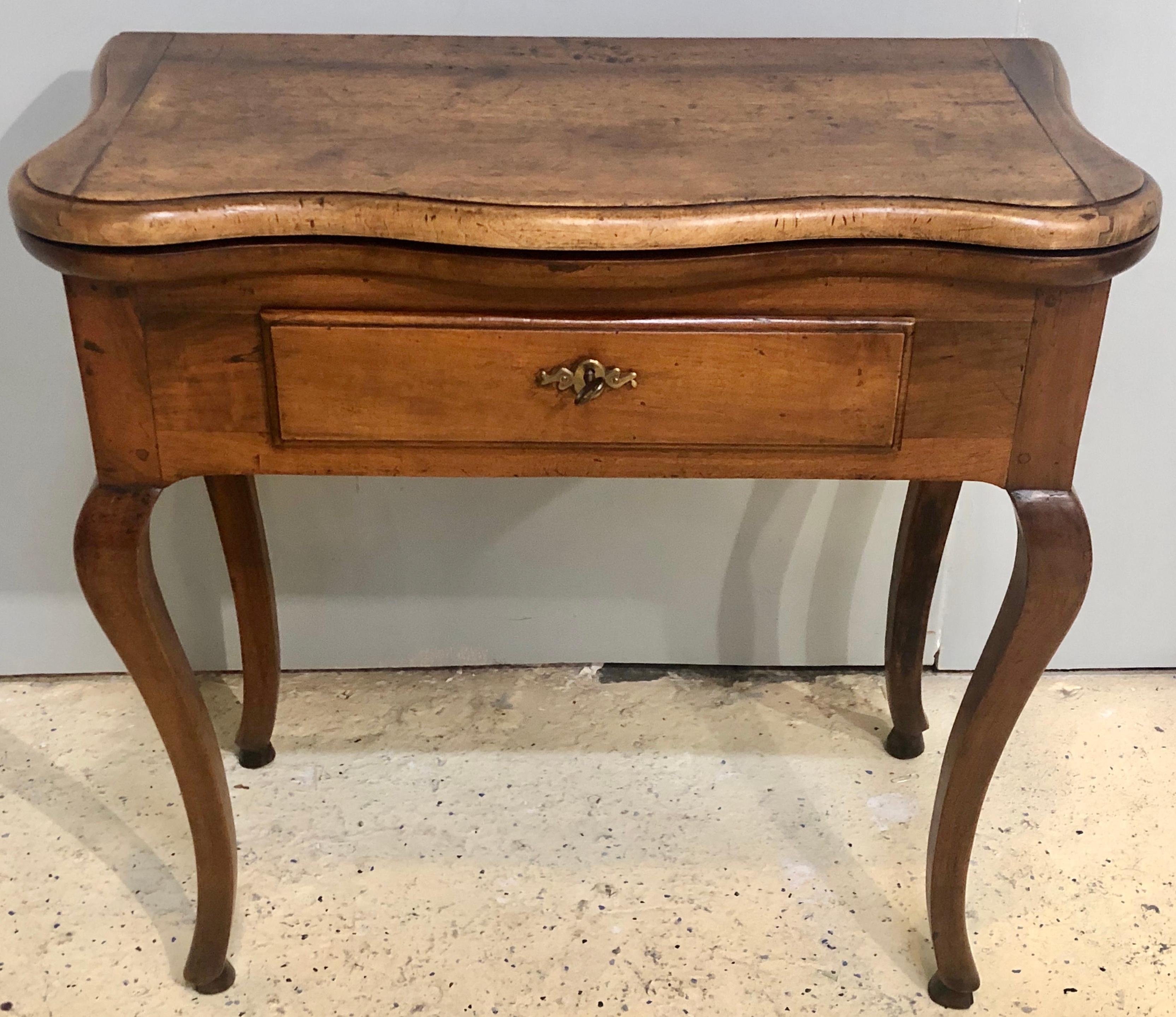 A Period Louis XV walnut and fruitwood game table 18th century. This stunning one of a kind game or flip top table circa 1760s is in rather nice condition given the age. The sleek and slender curved legs supporting a single drawer flip top card