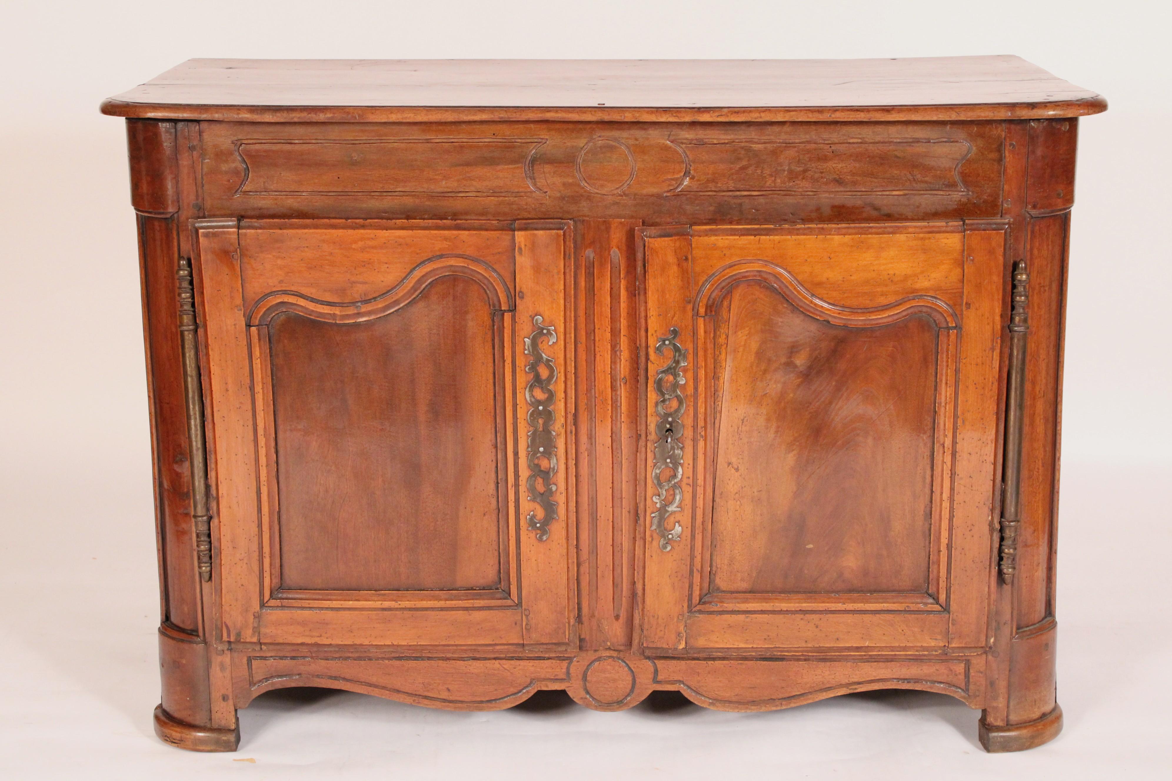 Buffet a due ante in noce Luigi XV, XVIII secolo. Con un piano rettangolare a due tavole con angoli anteriori arrotondati, due porte a pannelli con scure in noce ben lavorato e scudi in acciaio,  un doppio grembiule a forma di serpentina, fianchi a