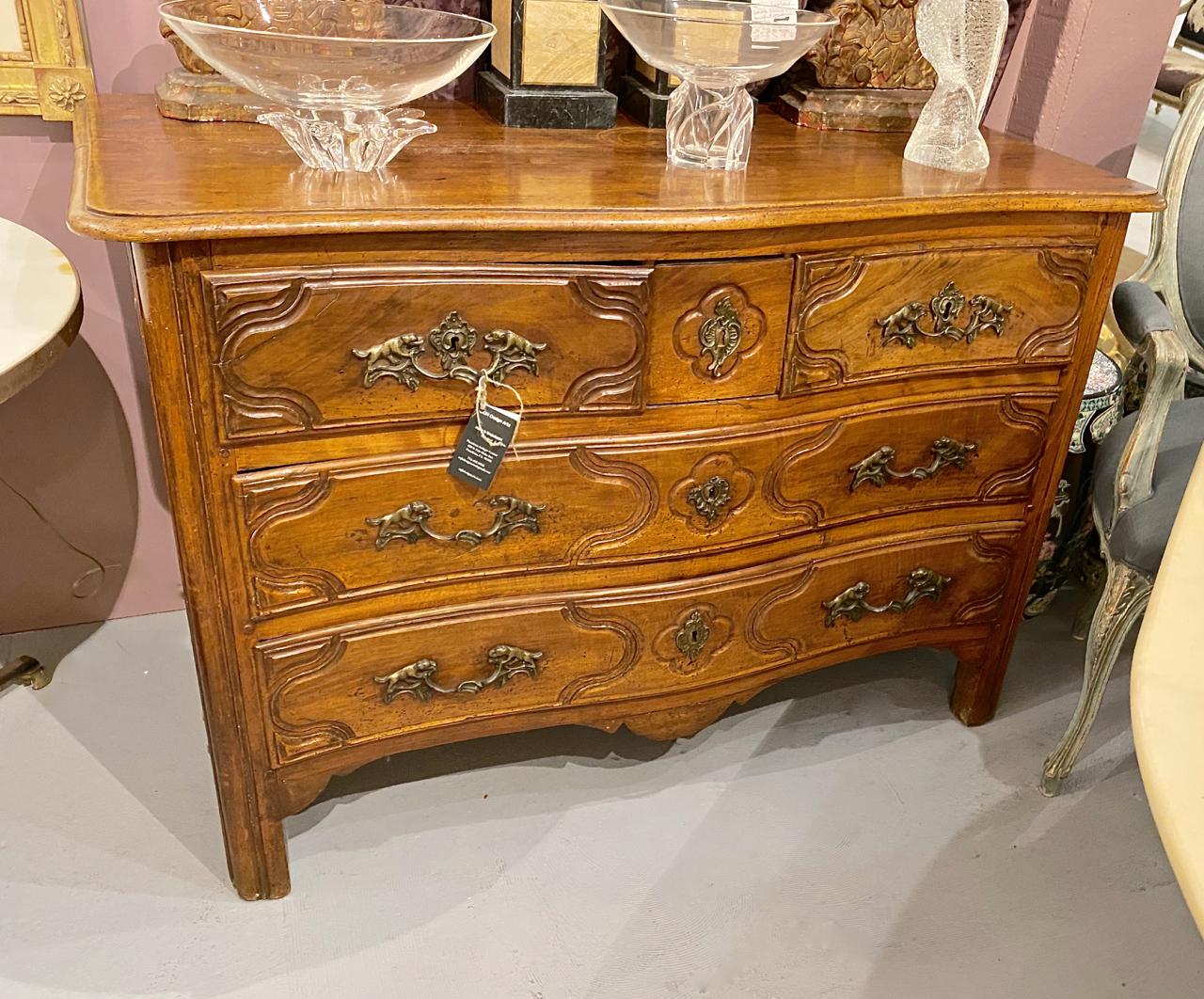 This is a fine example of a mid-18th century Louis XV provincial serpentine walnut chest of drawers. The chest is in overall very good condition. The chest features a serpentine front, molded top, 4 carved drawers with a 