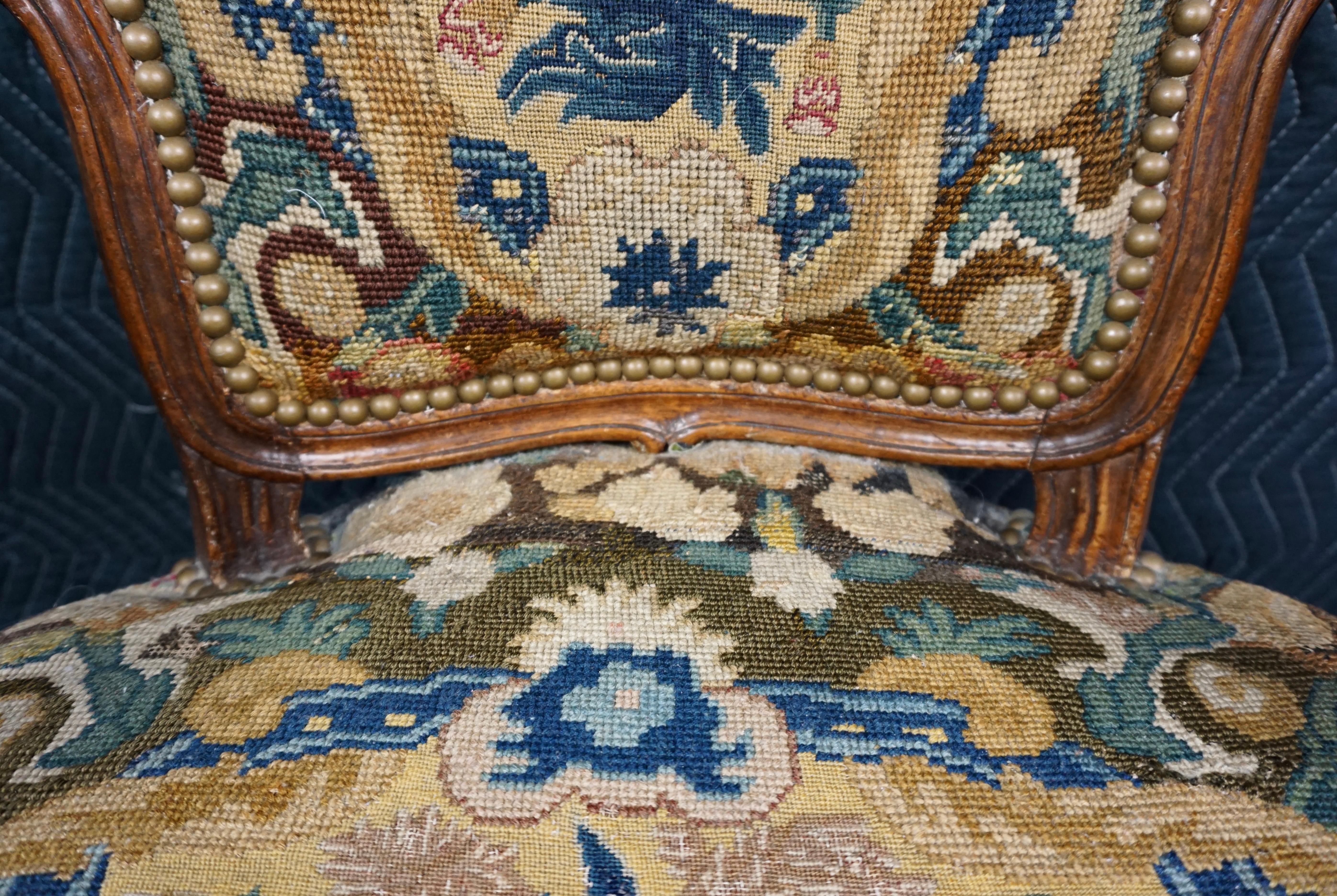 A lovely small scale Louis XV style armchair upholstered in gros and petit point needlework, the frame with well carved details on the crestrail and seat frame. Circa 1800-1840.
