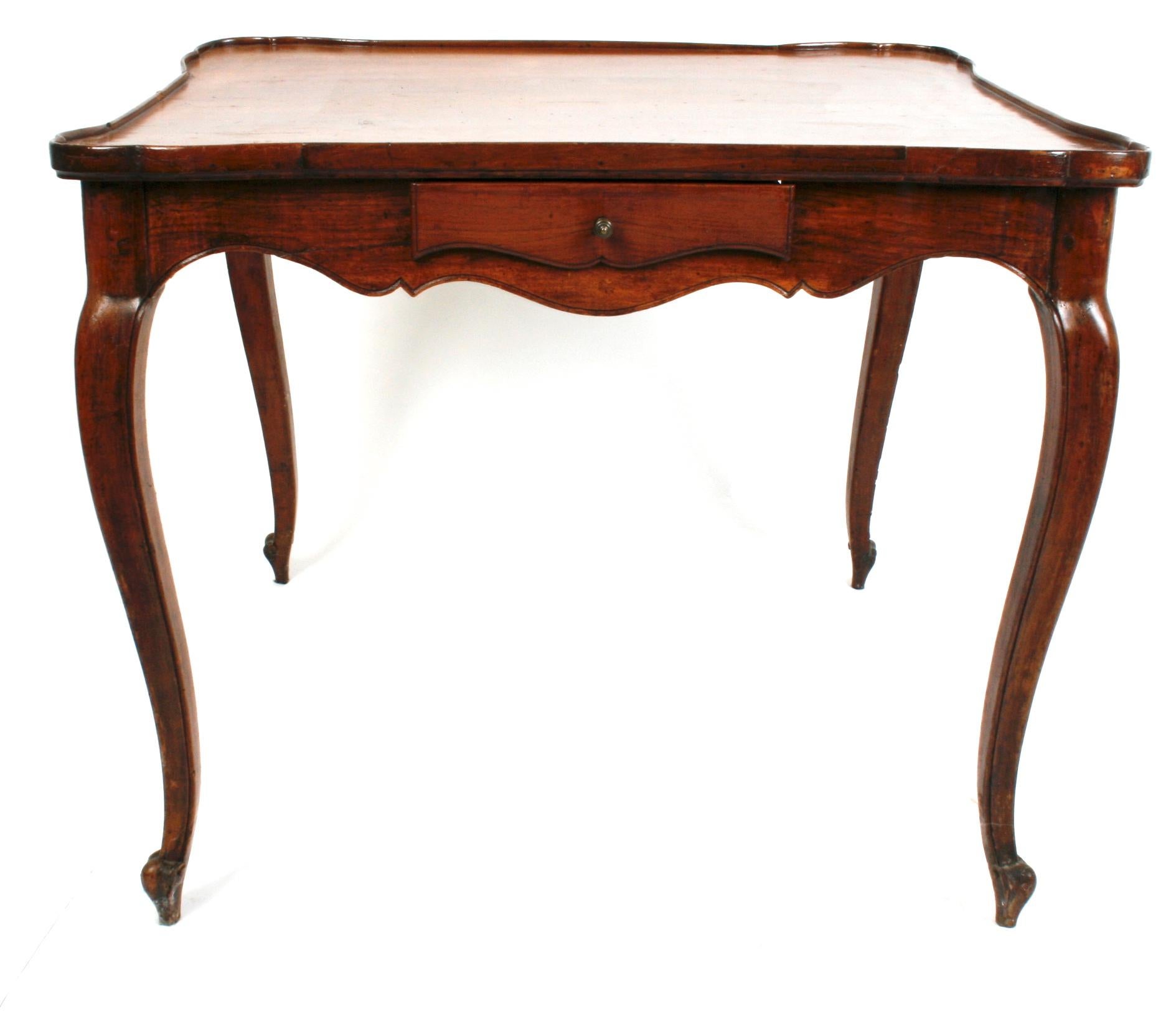 Louis XV walnut table with galleried top, circa 1780. The table has a scalloped apron, a scalloped drawer on each side, and cabriolet legs that end with scrolled feet. 
N.P. Trent has been a respected name in antiques for over 30 years with a large