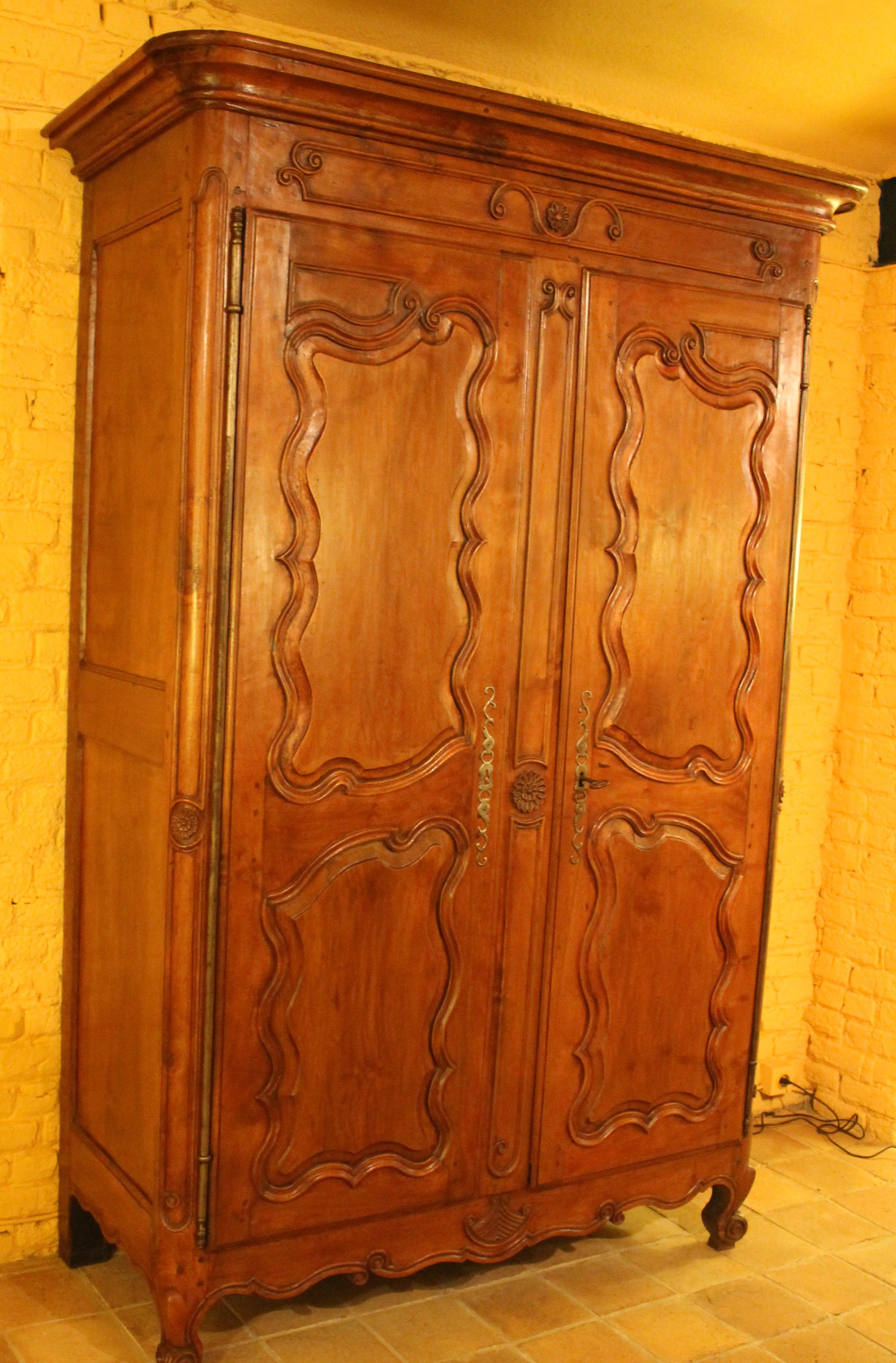 Very beautiful French 18 century armoire in wildcherry wood from the West part of France 

Extraordinary piece in cherrywood with beautiful flower carving
 We can notice that the wardrobe still has here original irons and keys and here original
