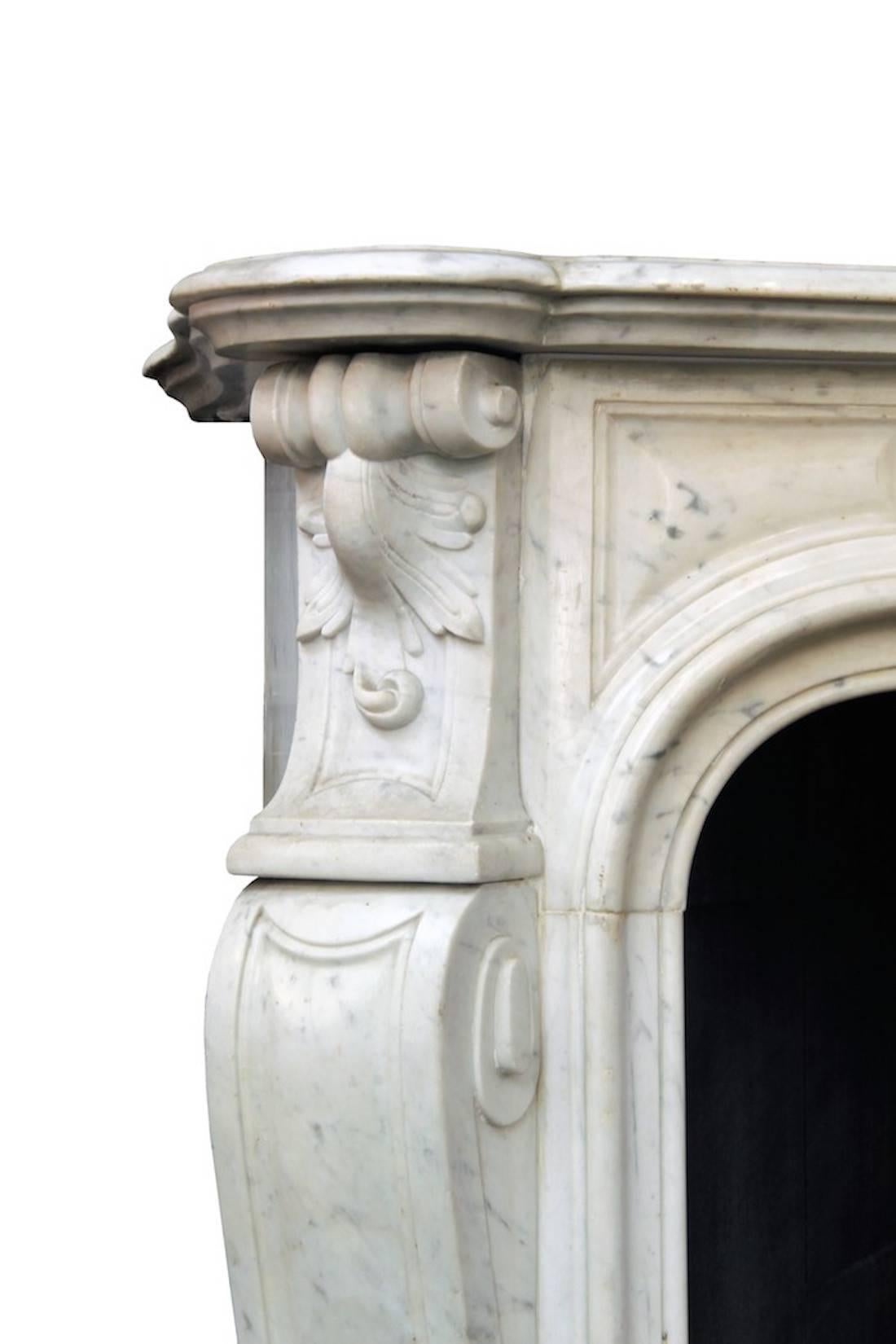 Large French Louis XV style mantle fireplace in white Carrara marble, 19th century﻿.
Refined and sinuous shapes and overall very minimalist, this elegant antique Louis XV style fireplace was made of Carrara marble during the 19th