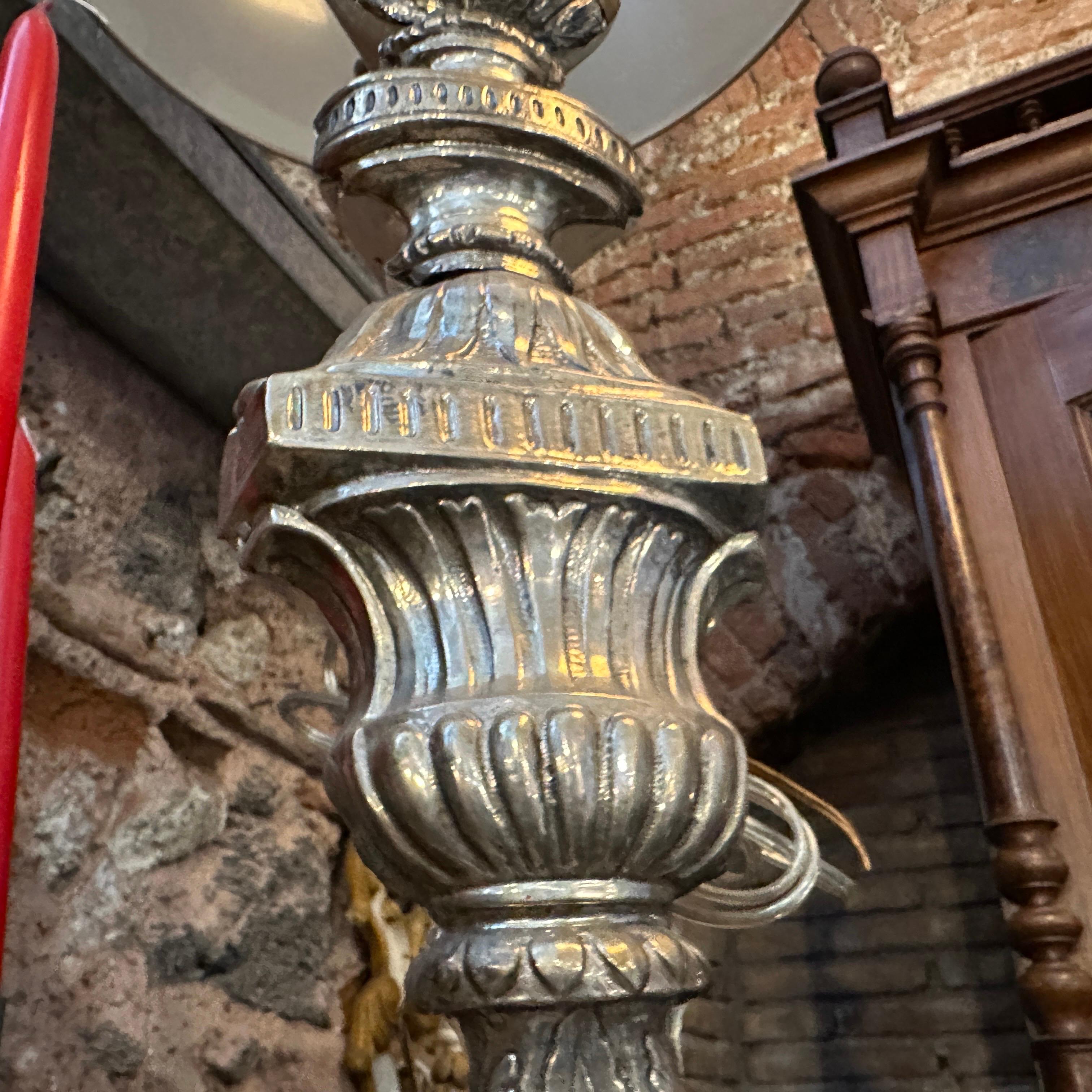 Questa è una torchère italiana del XVIII secolo in stile Luigi XV che è stata trasformata in una lampada da tavolo. La lampada è caratterizzata da una base in legno intricatamente intagliata e ornata da dettagli decorativi e da un metallo rifinito