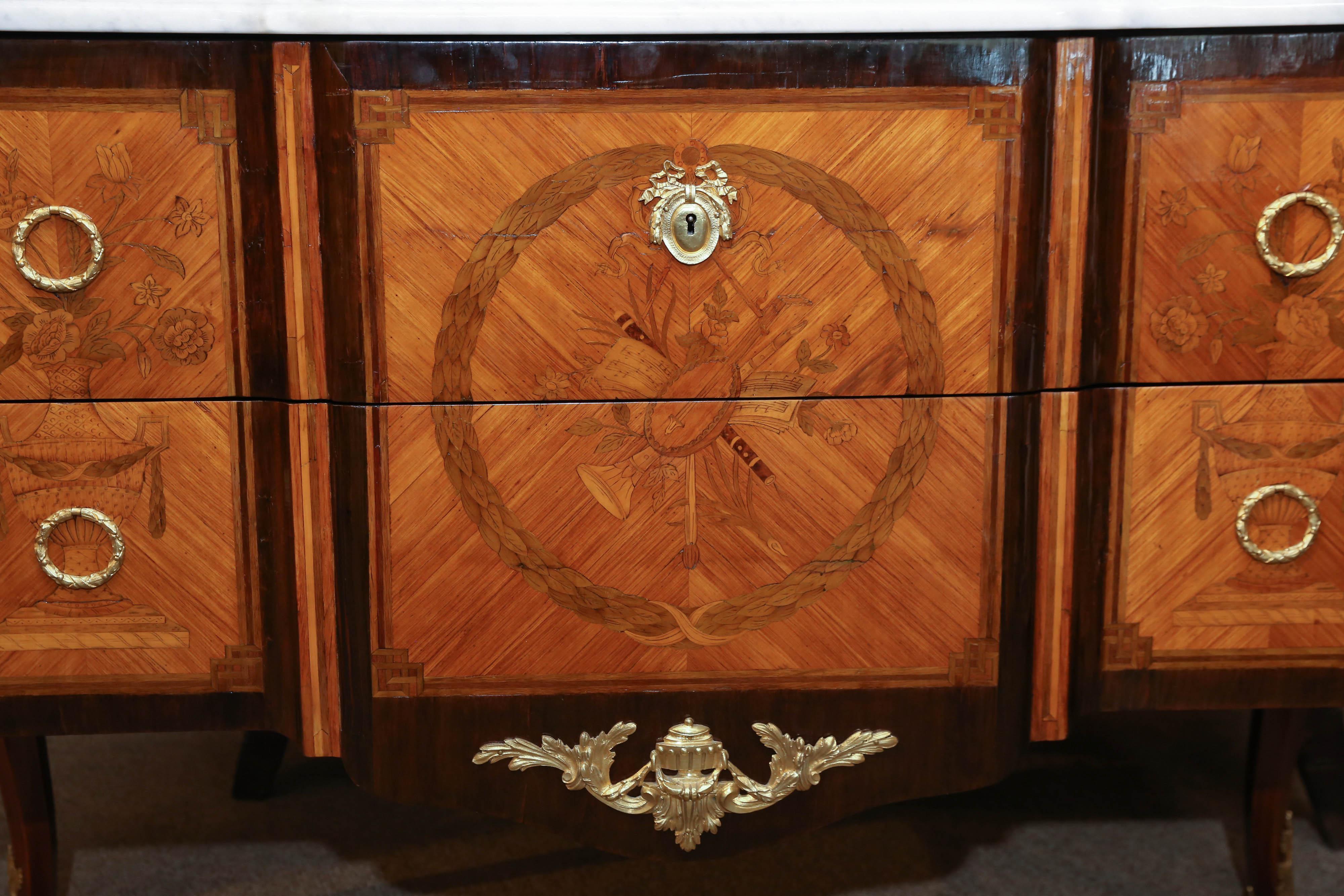 White marble-top rounded on the corners over a rectangular
Breakfront above a conforming case fitted with two long
Drawers, quarter-veneered and centered by a musical 
Marquetry design, flanked to either side by decorative floral
Inlays, raised