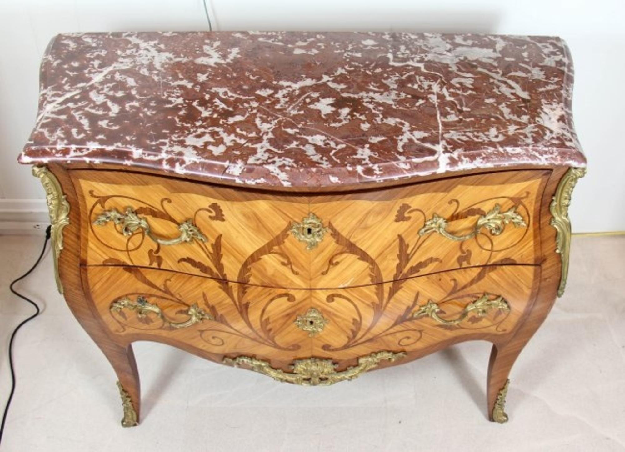 A Louis XV/XVI style transitional ormolu-mounted tulipwood, kingwood and fruitwood marquetry commode, centred by a lock on each drawer, serpentine sided rouge royal marble top.
A fine Louis XV style tulipwood and amaranthe marquetry commode, 19th