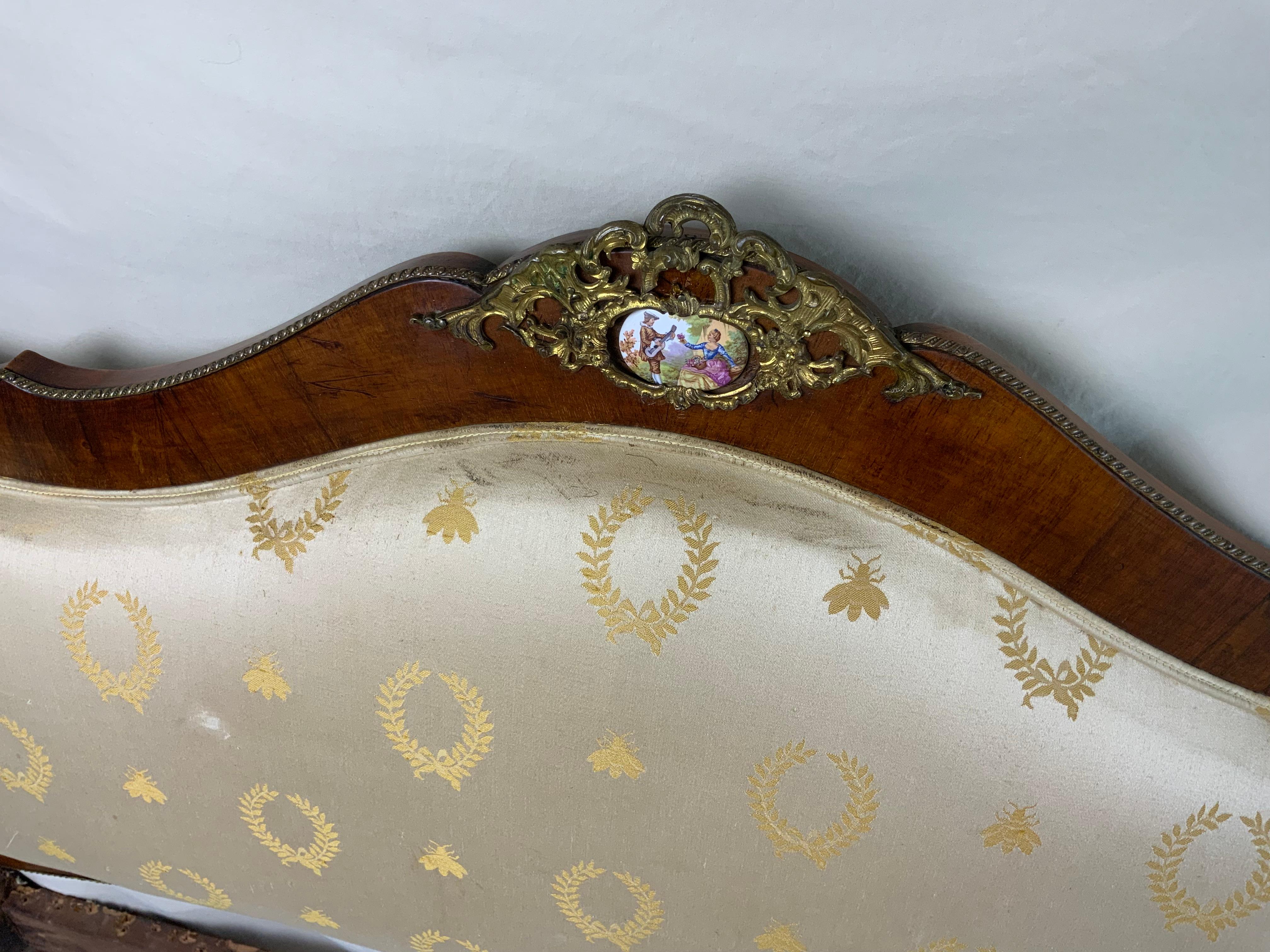 Very attractive Louis XV1 Walnut settee with hand painted Porcelains and Ormolu trim. This piece retains its original surface and a great aged color and patina to the French polish Walnut surface. The frame side rails had some movement in them so