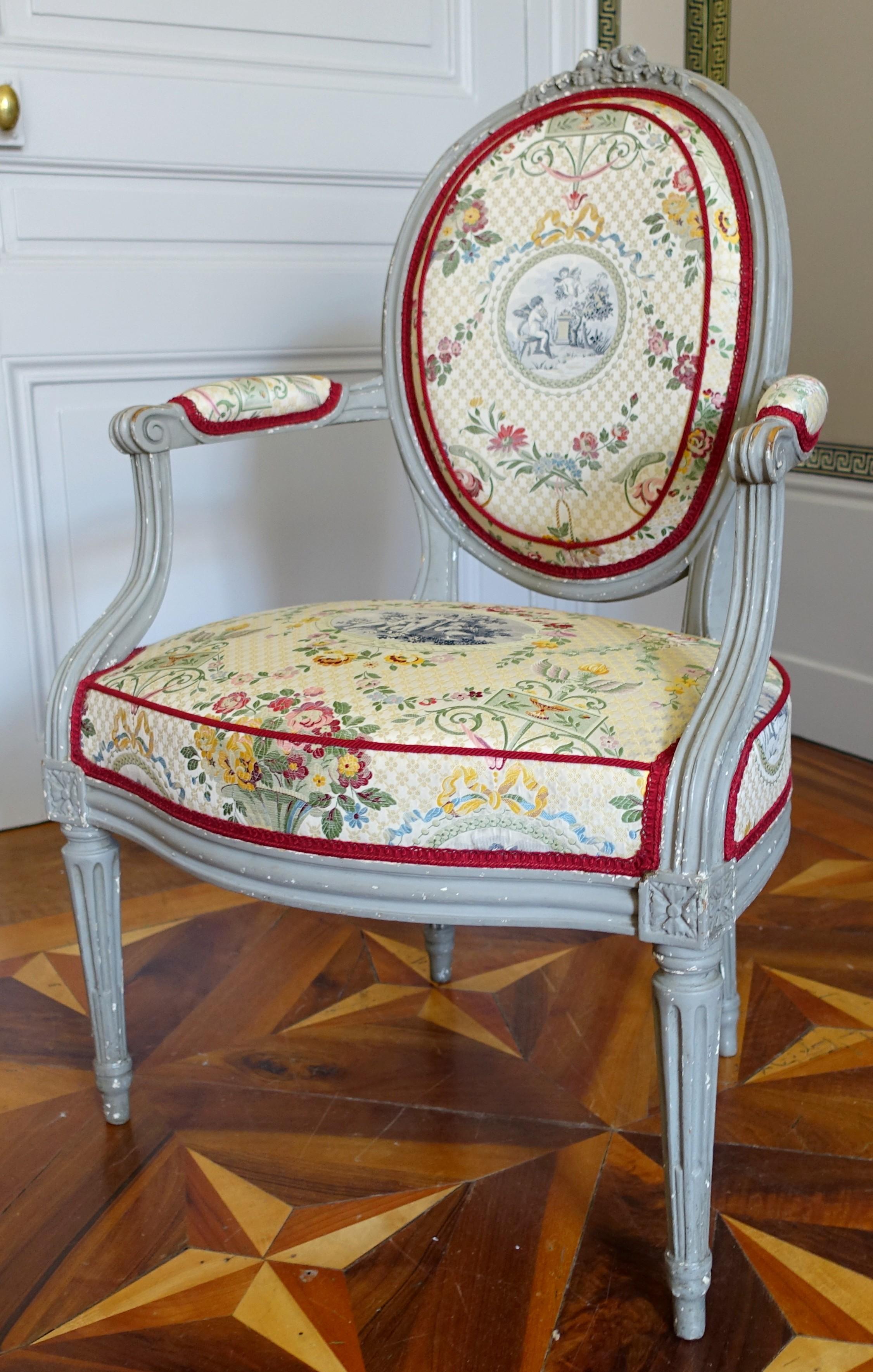 Poltrona cabriolet laccata, schienale a medaglione, periodo Luigi XVI, circa 1780. Le sedute recano sotto il timbro del prestigioso produttore parigino Claude Séné II.
È rivestito con una bellissima seta in stile neoclassico Luigi XVI (di Lelièvre