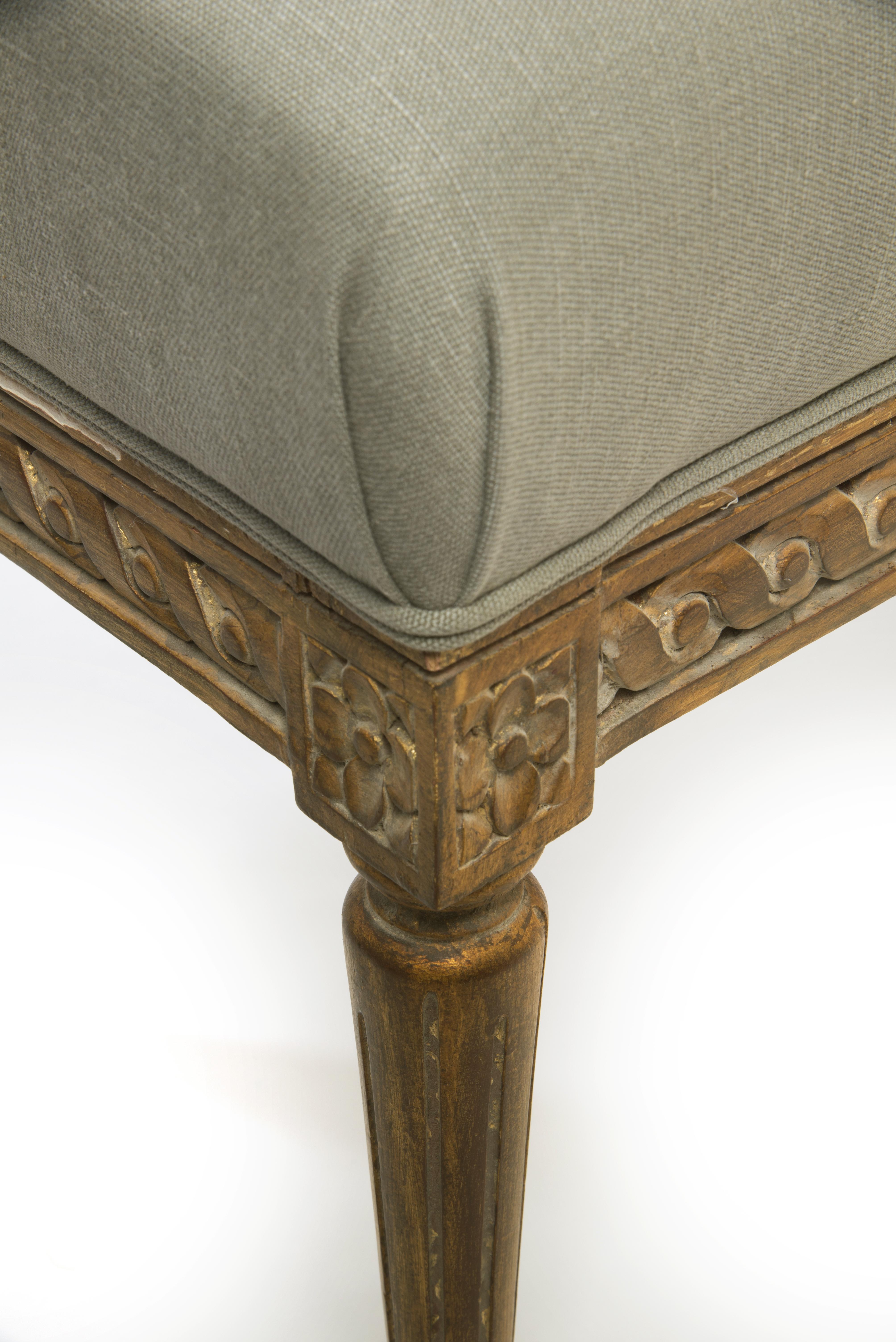 This beautifully made bed bench in the style of Louis XVI features stunning wood carvings that give this furniture piece a bold statement. Upholstered with high-quality linen fabric from the de Le Cuona collection this bench is great for adding