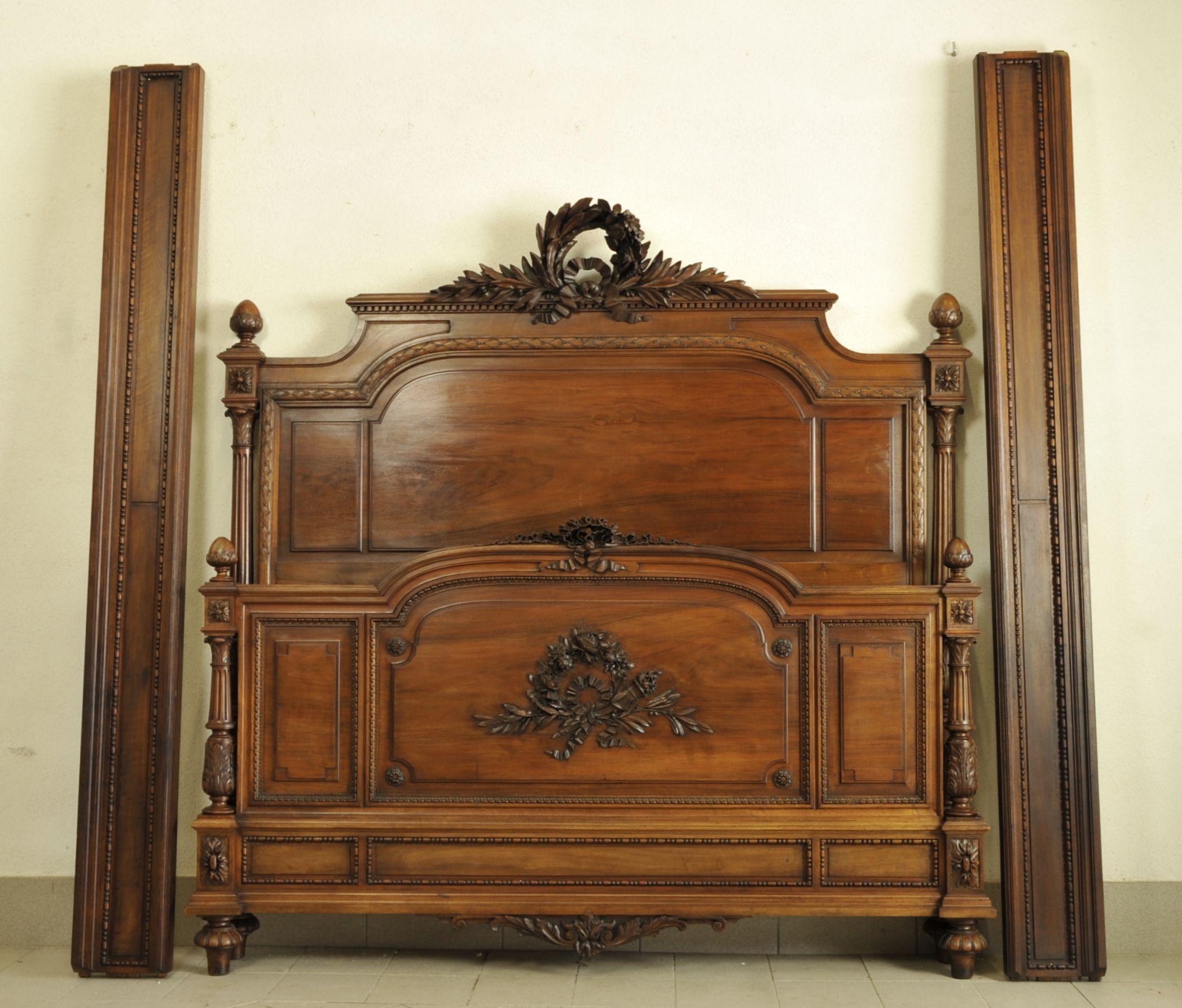 Louis XVI bedroom furniture in solid walnut very richly carved with beaded and gadrooned friezes, mistletoe crowns adorned with flowers and ribbons, and other neoclassical-inspired ornaments.

Composed of a large bed and a large wardrobe with
