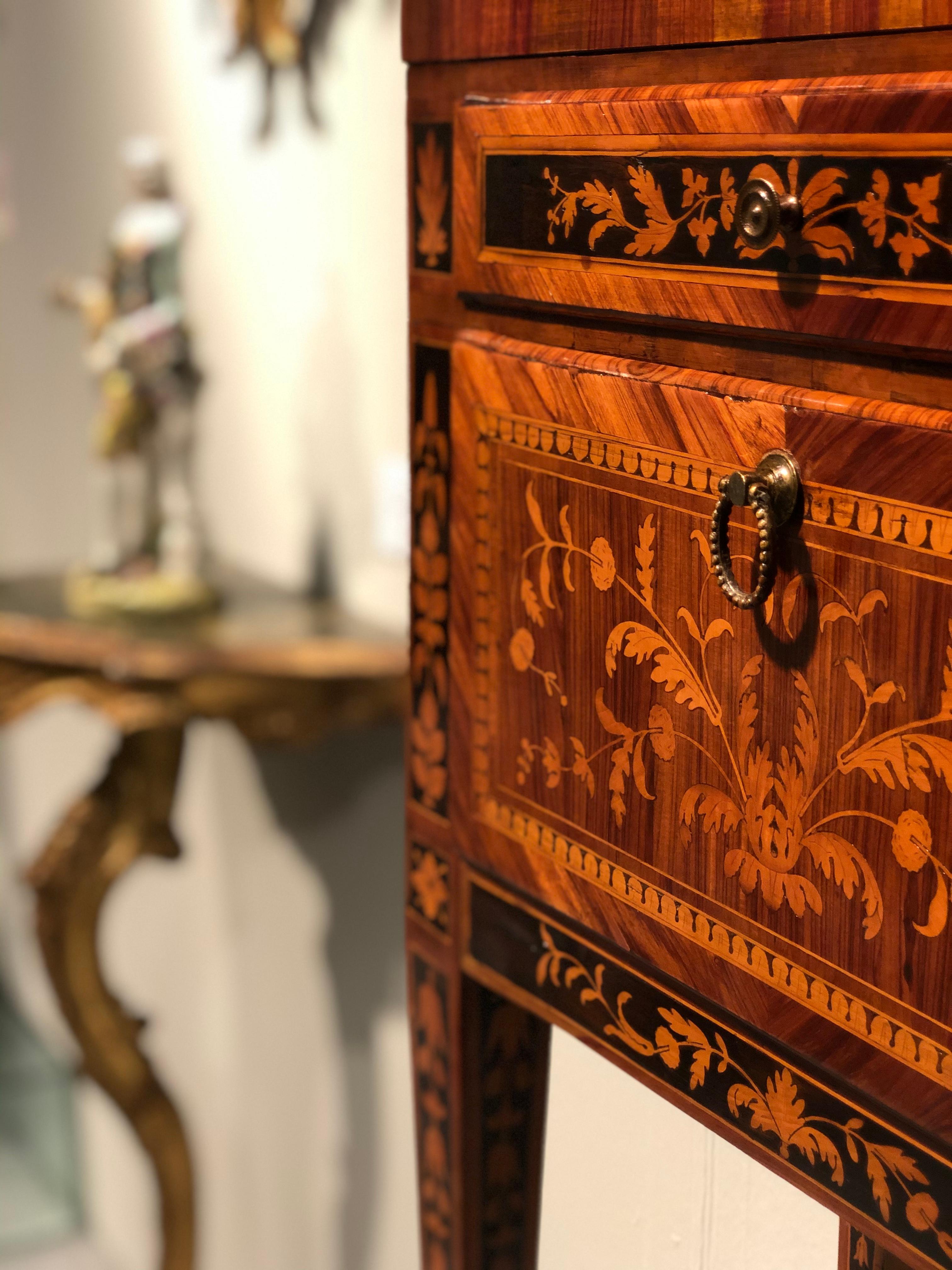 This refined bedside table/small sideboard was made in Lombardy (Italy) in the neoclassical period, towards the end of the 18th century.
The wooden structure is veneered and decorated with inlays in various essences.
The front of the neoclassical