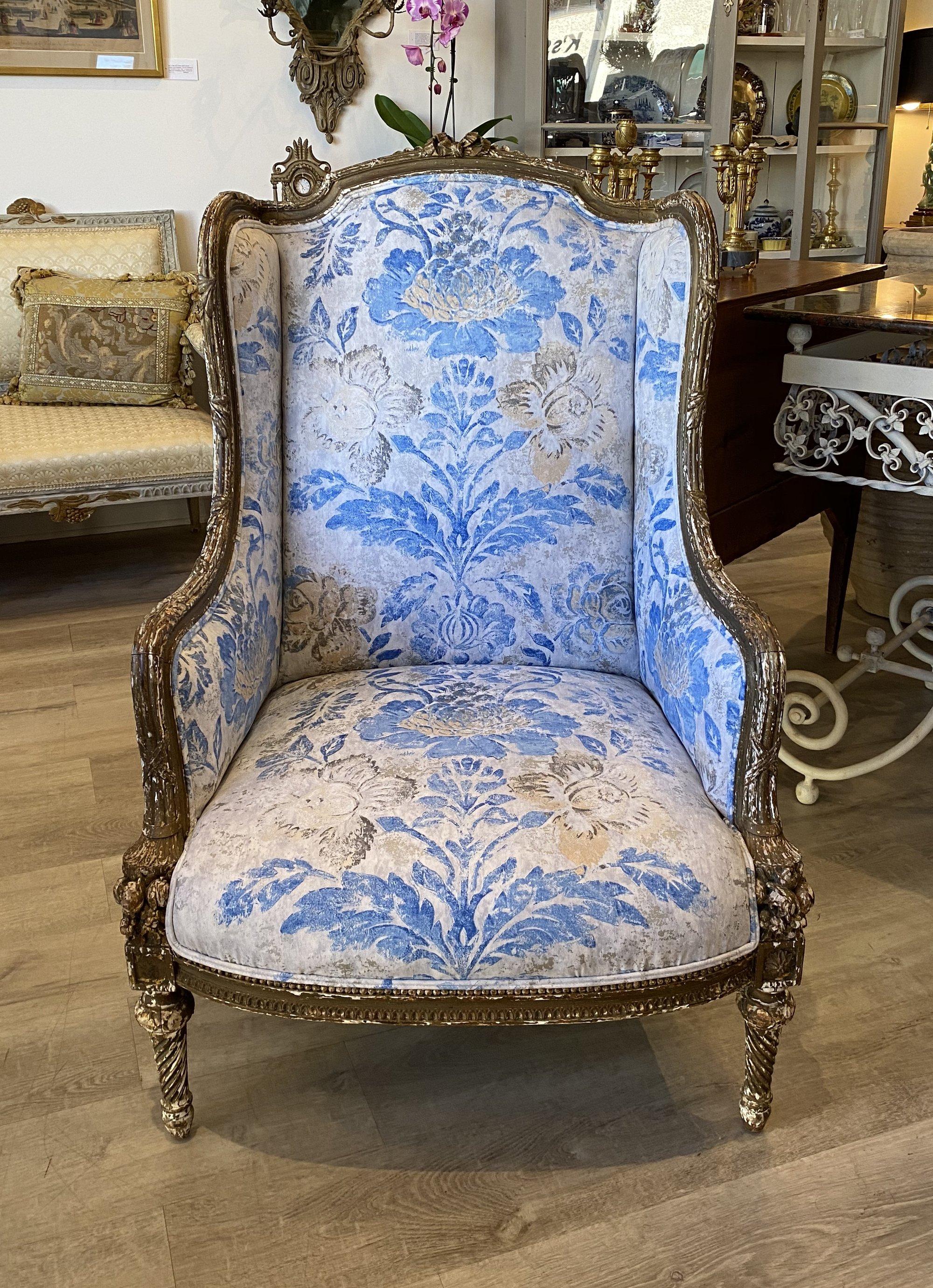 Louis XVI Berger an Oreilles, armchair, early 18th-late 19th century, 18th century or later, carved and giltwood, crested by a French bow with channeling, terminating in a cornucopia; spiral turned legs. Newly upholstered in Designer’s Guild fabric.