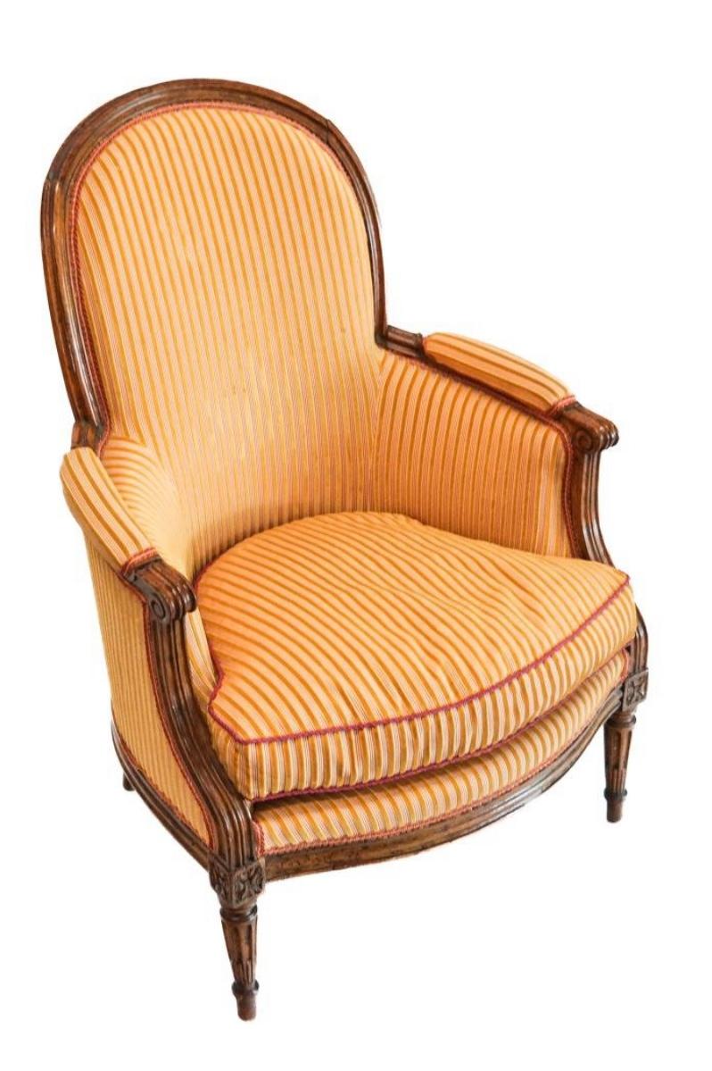 Silla bergere de época Luis XVI, hacia 1790, con respaldo arqueado y patas acanaladas, tapizada recientemente en tela a rayas con asiento de cojín suelto. Muy buena escala. Excelente calidad. 