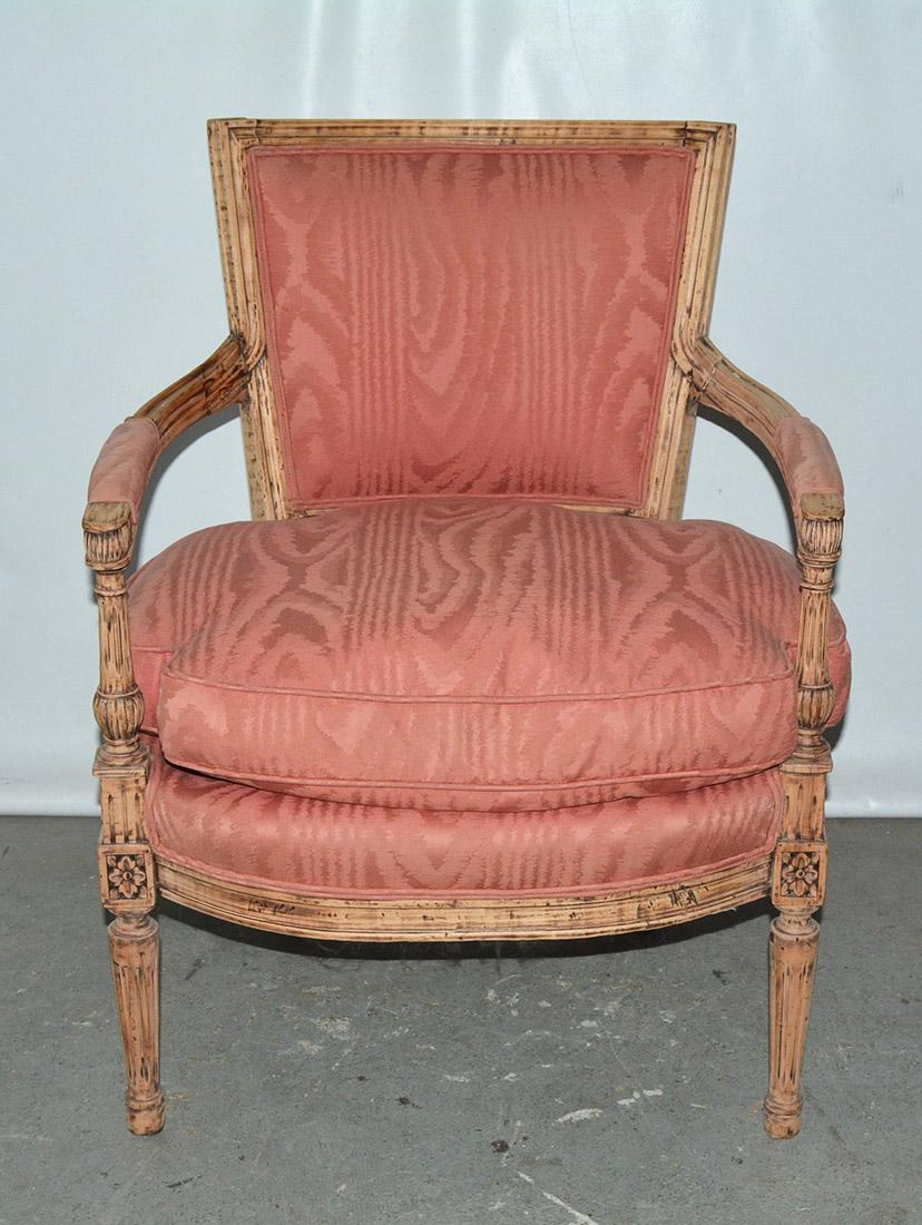 French Louis XVI stripped armchair giving it an informal casual charm with rose dust moire upholstered back & overstuffed feather seat cushion over fluted turned legs, wonderful hand carved details and proportions. 
Upholstery and arms and the back