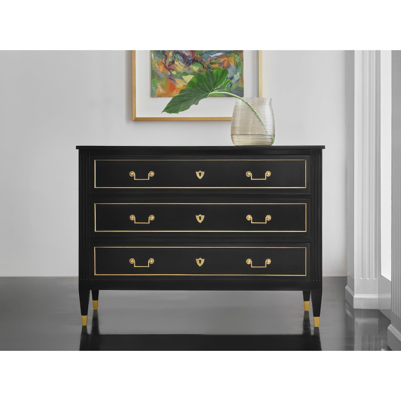 Questo comodino, che affonda le sue radici nel design del XVIII secolo, è caratterizzato da una cassa dipinta in ebano, da colonne scanalate e da gambe quadrate affusolate, elementi che richiamano l'arte classica francese.

I classici accenti e la