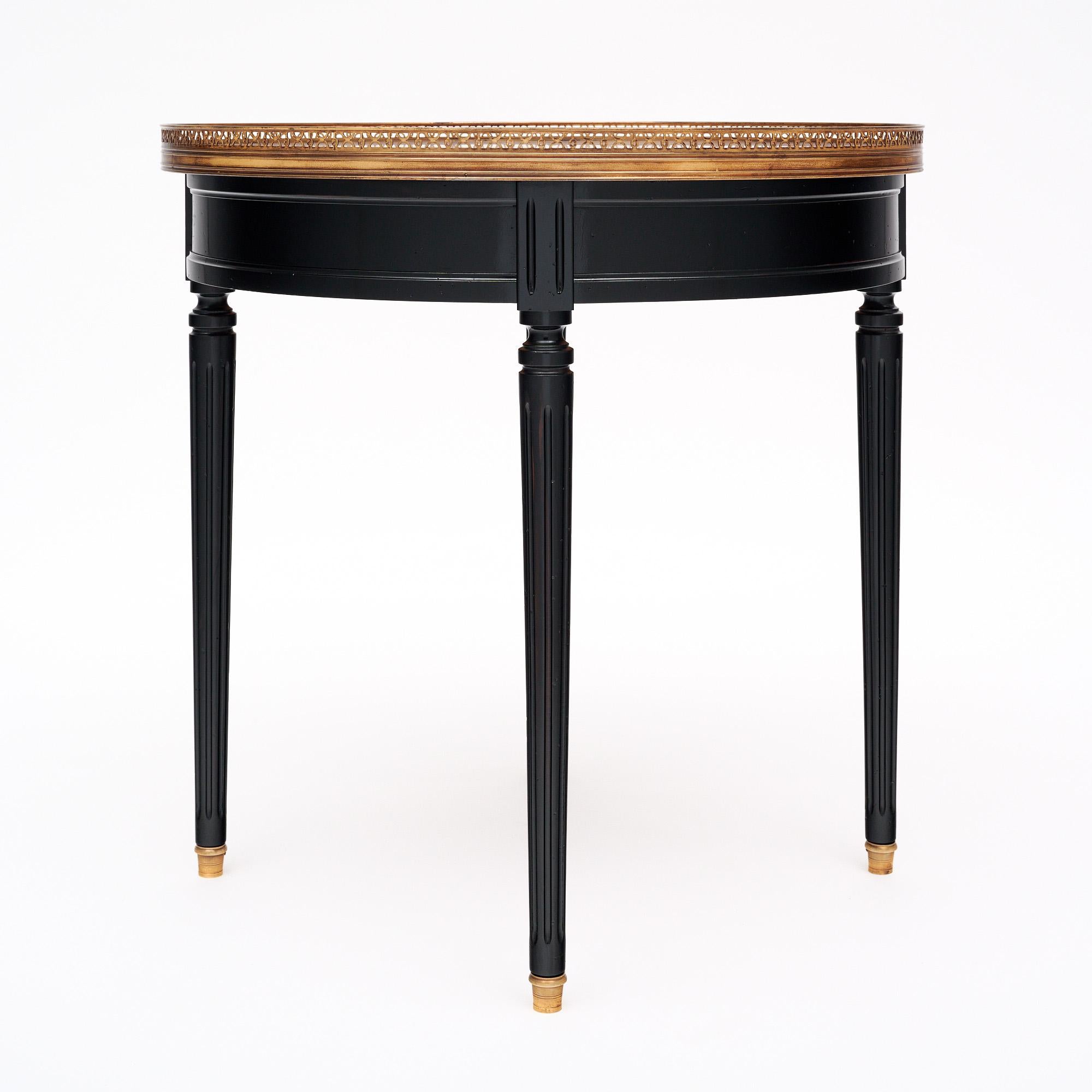 Table d'appoint française de style Louis XVI. Cette table de bouillotte, conçue à l'origine pour jouer à la bouillotte, a un plateau circulaire en marbre Brêche de couleur pêche, entouré d'un baldaquin ouvert en laiton. Il repose sur quatre longs