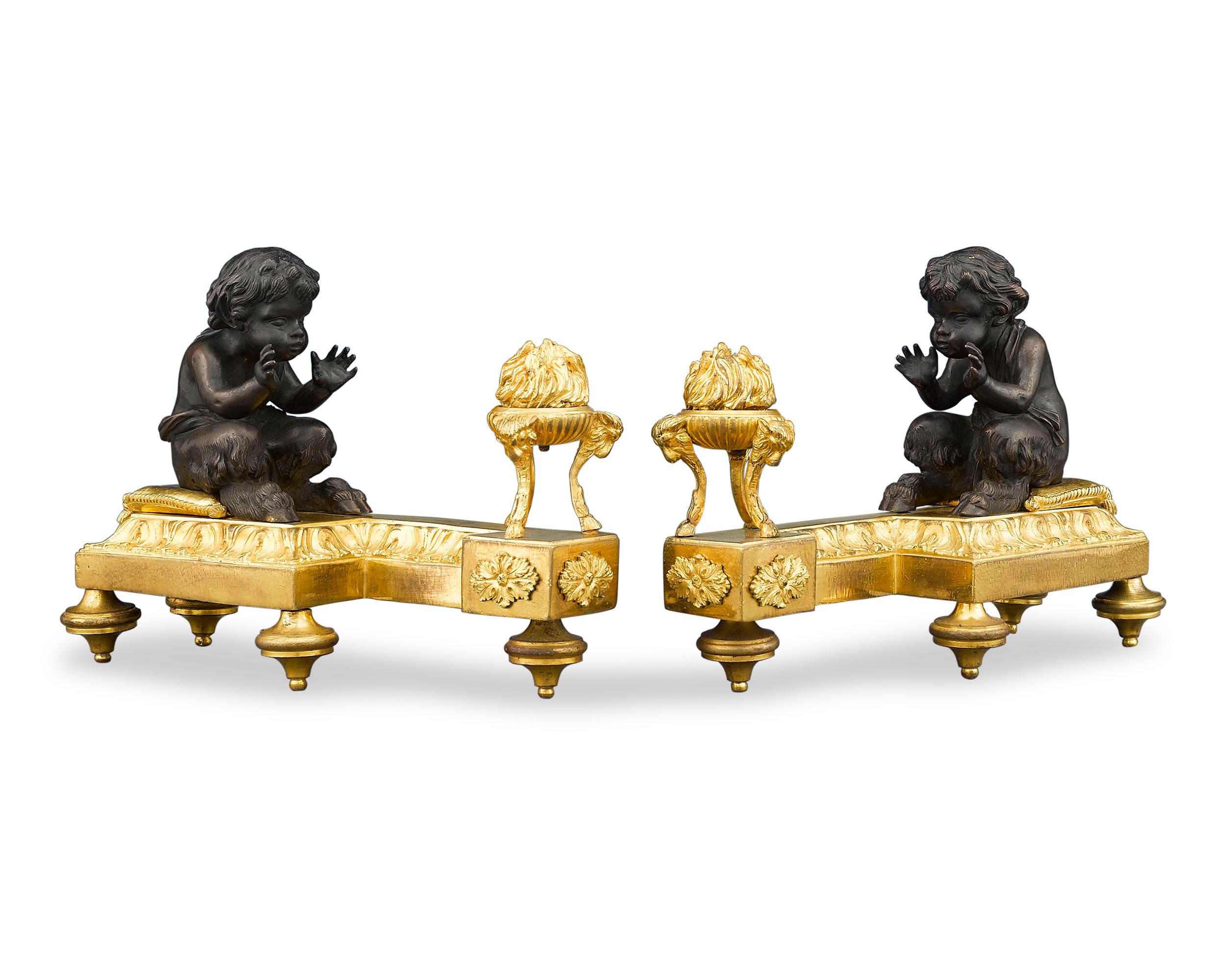 Two little fawns attempt to keep warm by brazier fire in this enchanting pair of French Louis XVI chenets, or fireplace andirons. Crafted of stunning doré and patinated bronze, these figures’ delightful neoclassical elegance is characteristic of