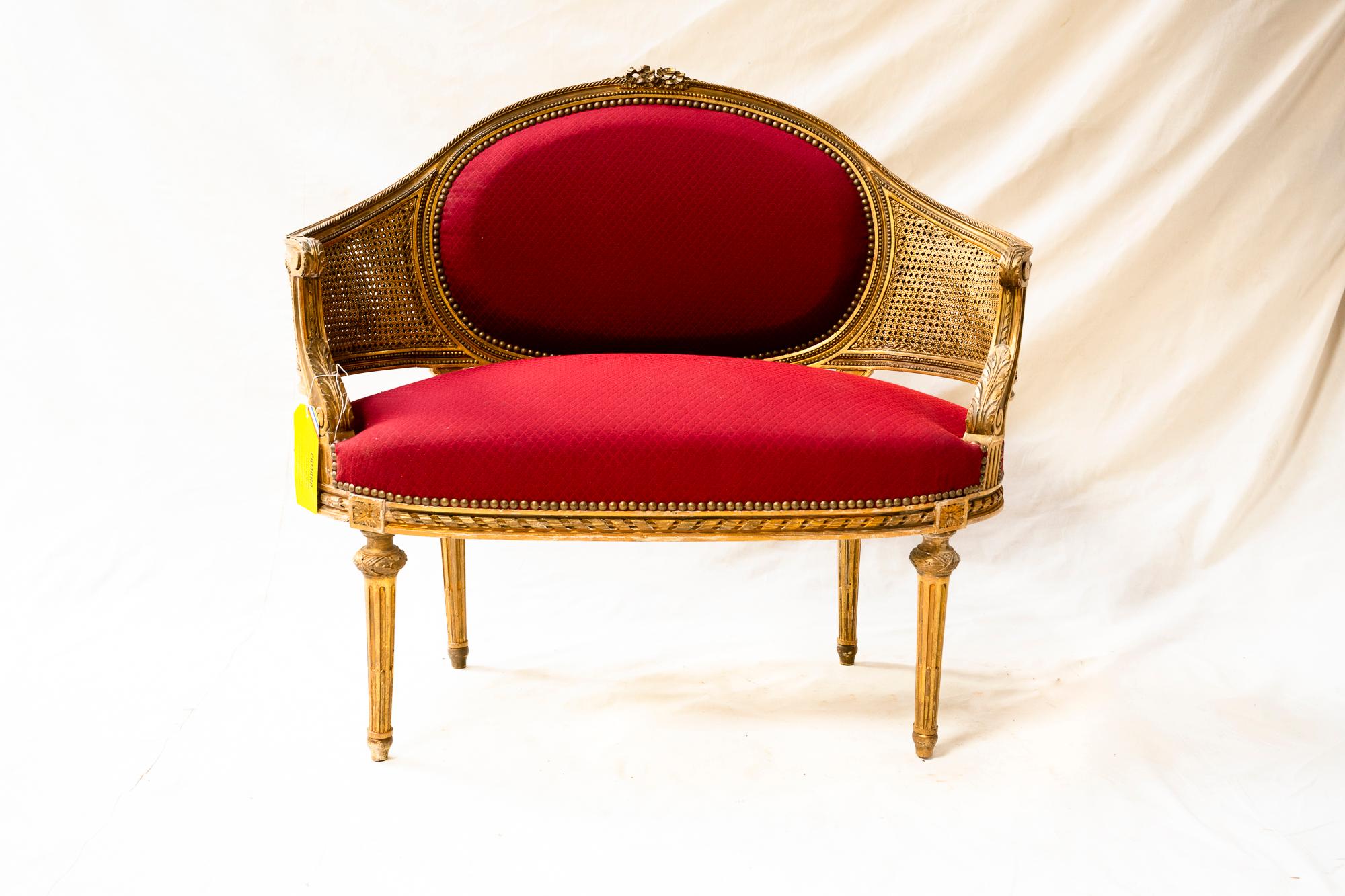This lovely gilt wood and double-walled gilltcane canapé was lovingly reupholstered in a bright red fabric in the Southwest of France, near the chateau where it was discovered, and can easily be recovered in a fabric of choice.
 