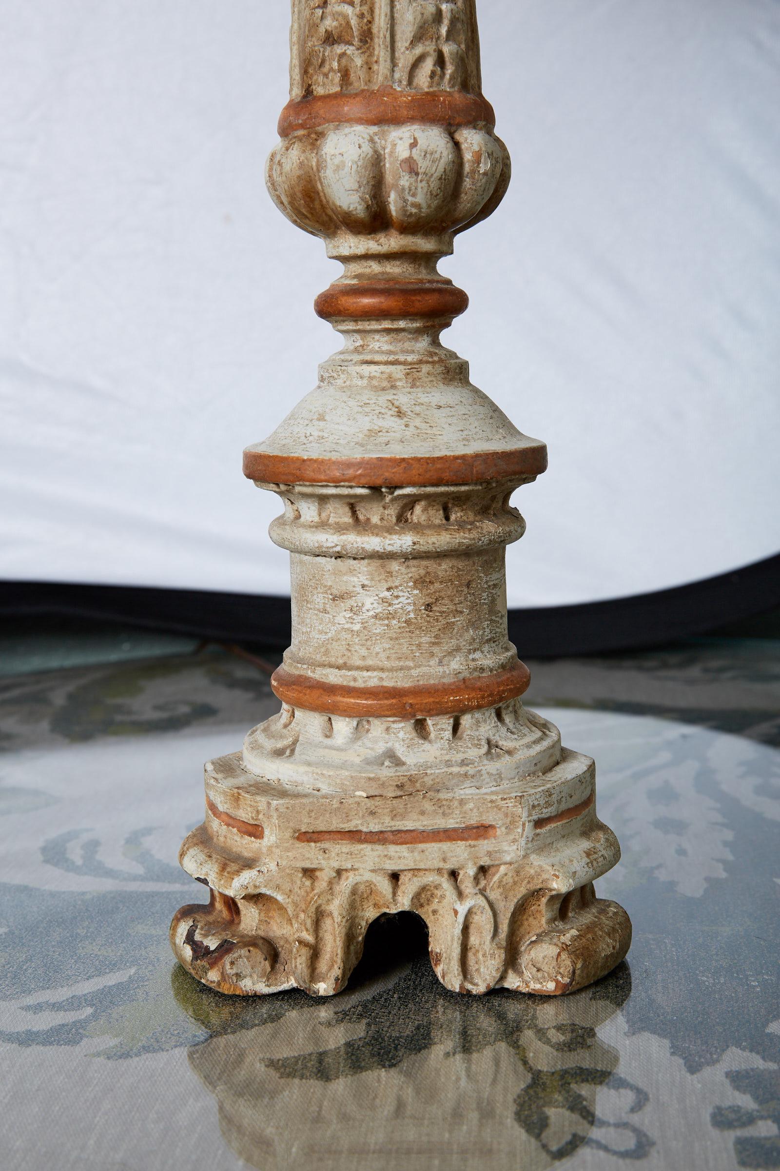 19th century French wooden alter candlestick in the Louis XVI style with the original cream and apricot colored paint on hand carved details. The candlestick was later wired as a lamp and is topped with a linen pleated ecru used lamp shade